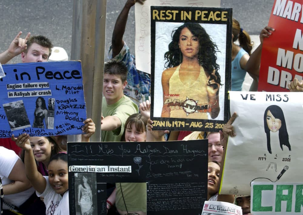 Fans holds signs in memory of actress and R&amp;B singer Aaliyah during TRL outside of the MTV studios in New York City on Aug 28, 2001. (Scott Gries/Getty Images)
