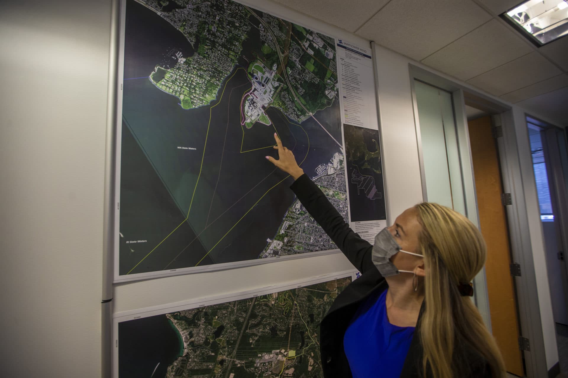 On a satellite image in the Mayflower Wind offices in Boston, Danielle Jensen points out where the power lines come on shore at Brayton Point in Somerset. (Jesse Costa/WBUR)