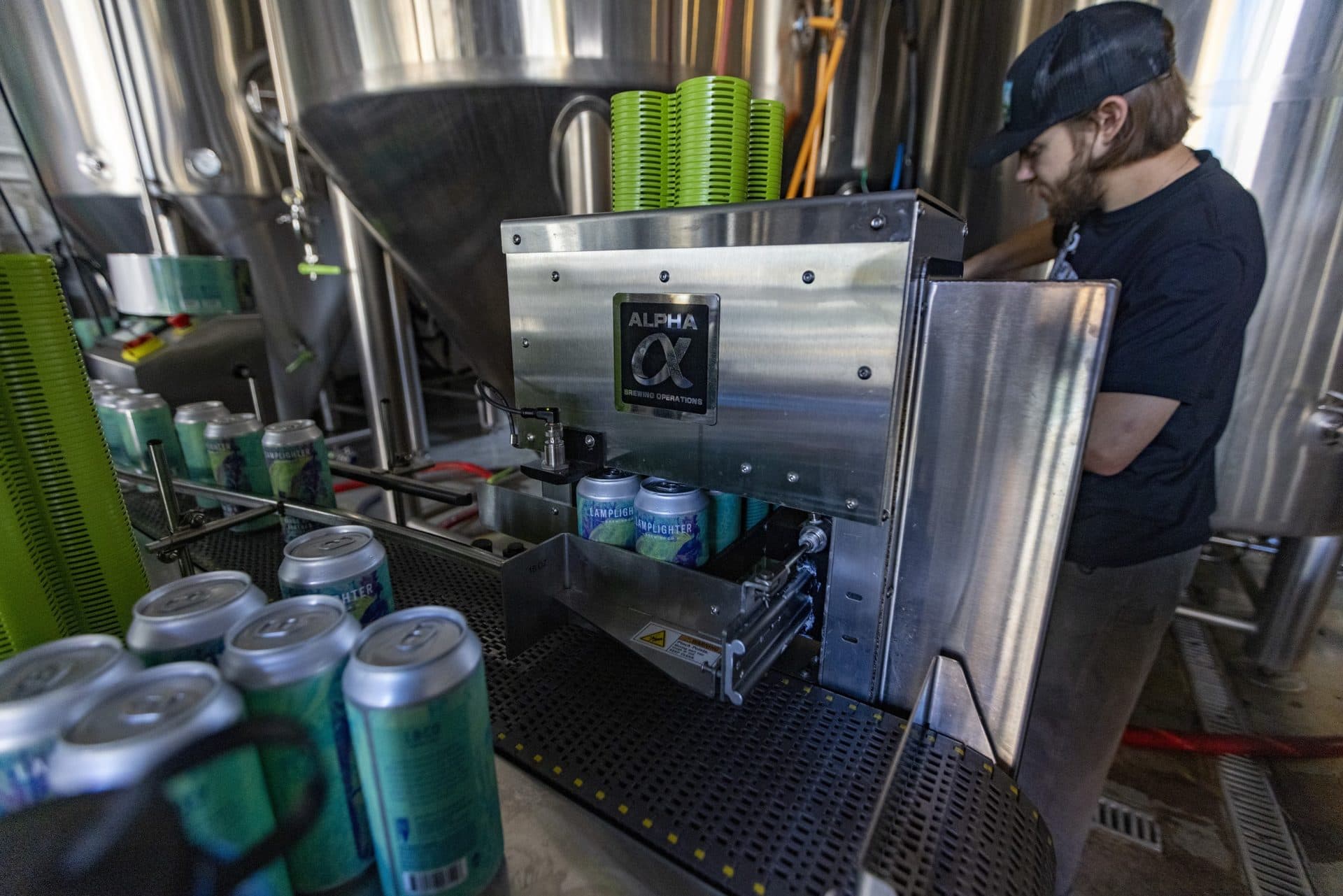 Cans of Birds of a Feather India Pale Ale travel through the Pack Tech Applicator, placing plastic carriers onto each 4 pack. (Jesse Costa/WBUR)