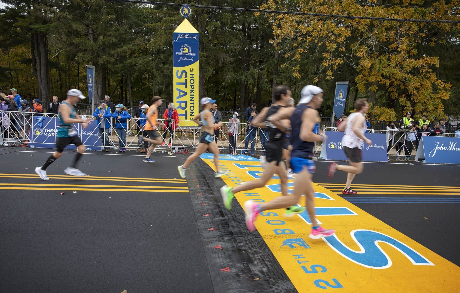 Runners cross the start line in the rolling start to the 125th Boston Marathon. (Robin Lubbock/WBUR)
