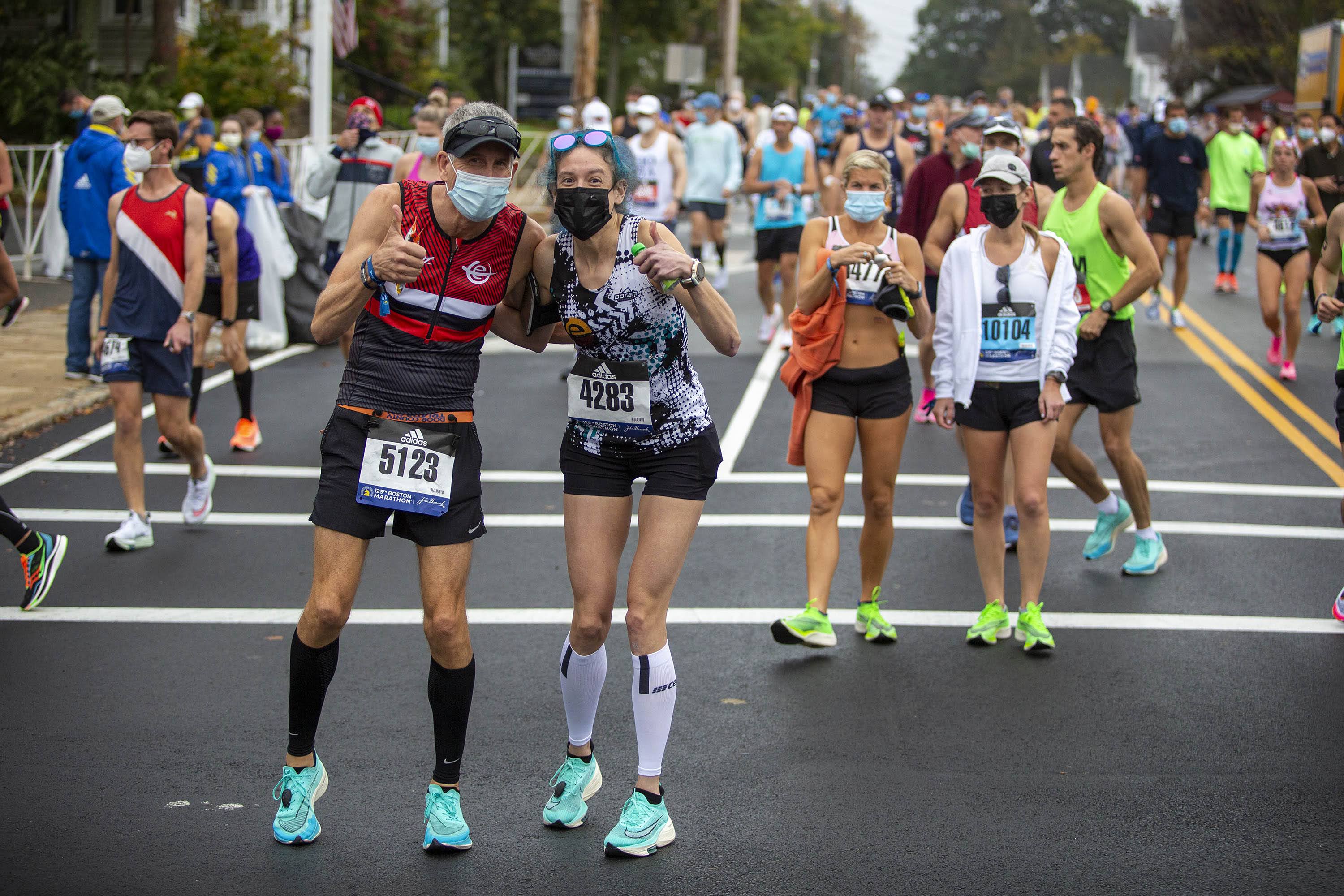Two runners pause in Hopkinton for a photograph as they make their way to the start line in the 125th Boston Marathon. (Robin Lubbock/WBUR)