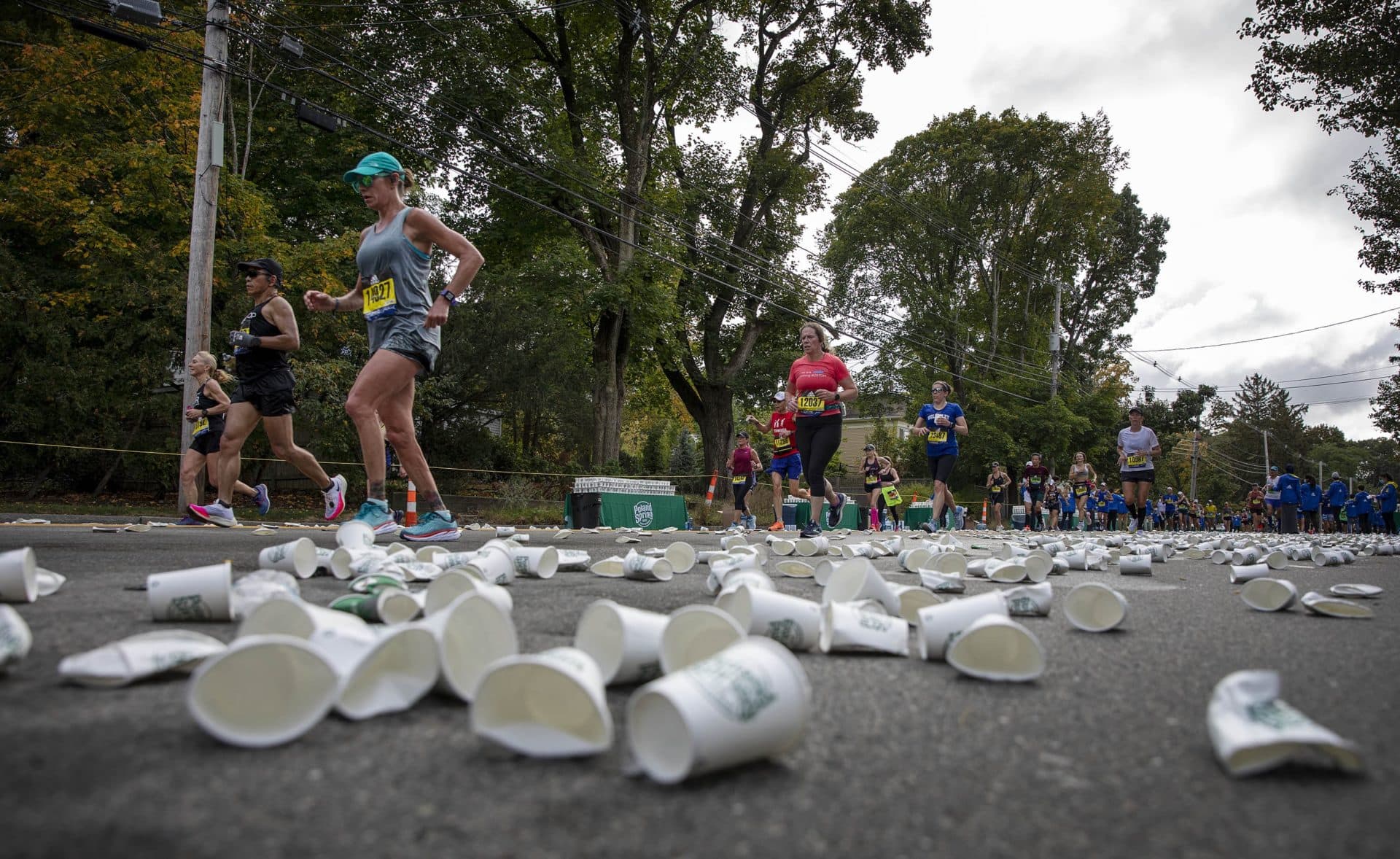 Discarded water cups litter marathon route at a water station in Newton. (Robin Lubbock/WBUR)