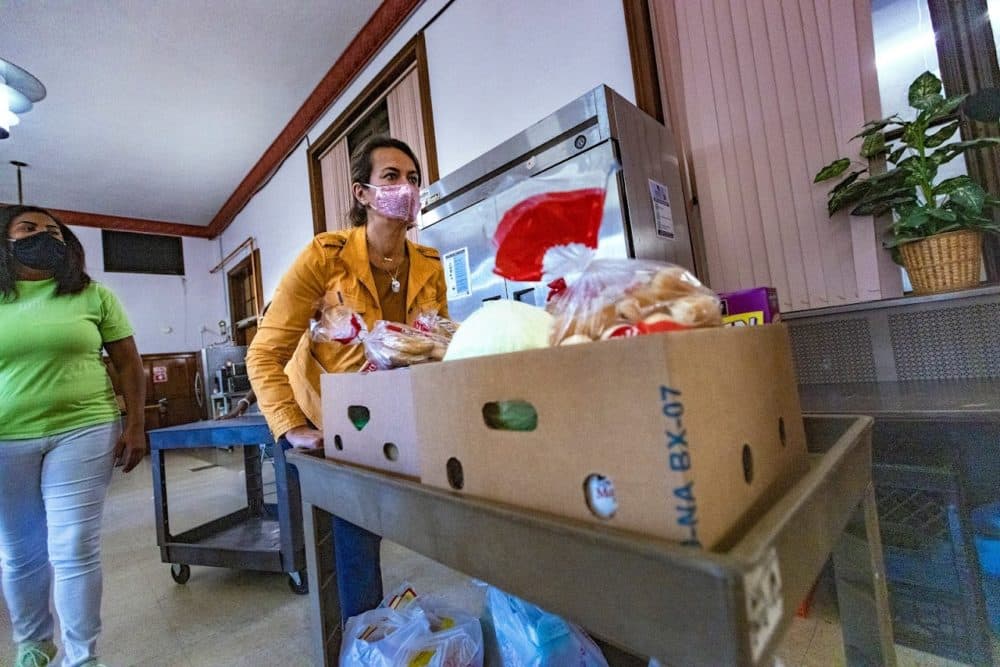 Boston mayoral candidate Annissa Essaibi George pushes a cart full of food donations for people in need at Shirley’s Pantry in Mattapan. (Jesse Costa/WBUR)