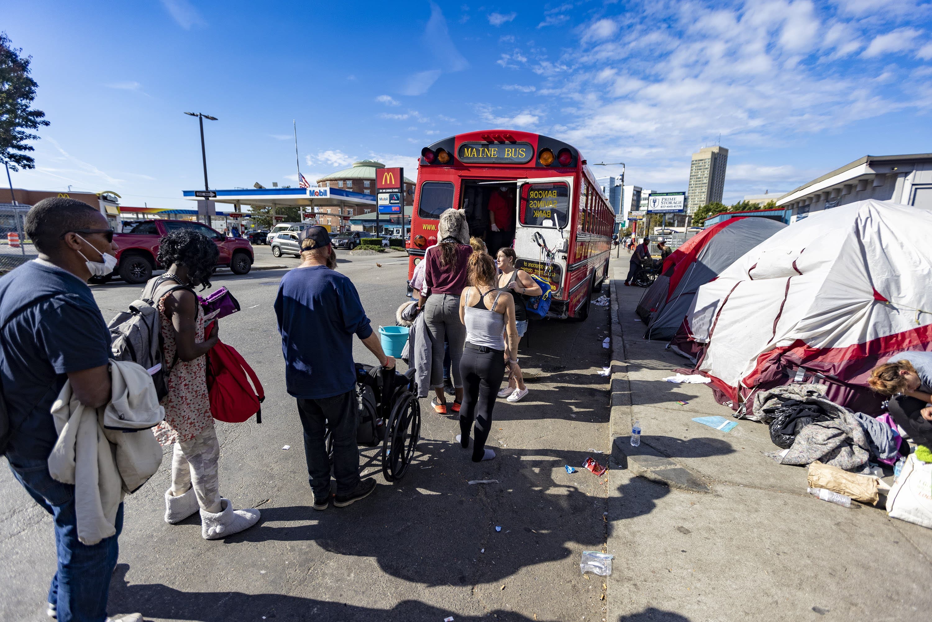 Several people struggling with homelessness and living around the "Mass. and Cass" area line up on Southampton Street for food supplies distributed by Support the Soupman. (Jesse Costa/WBUR)