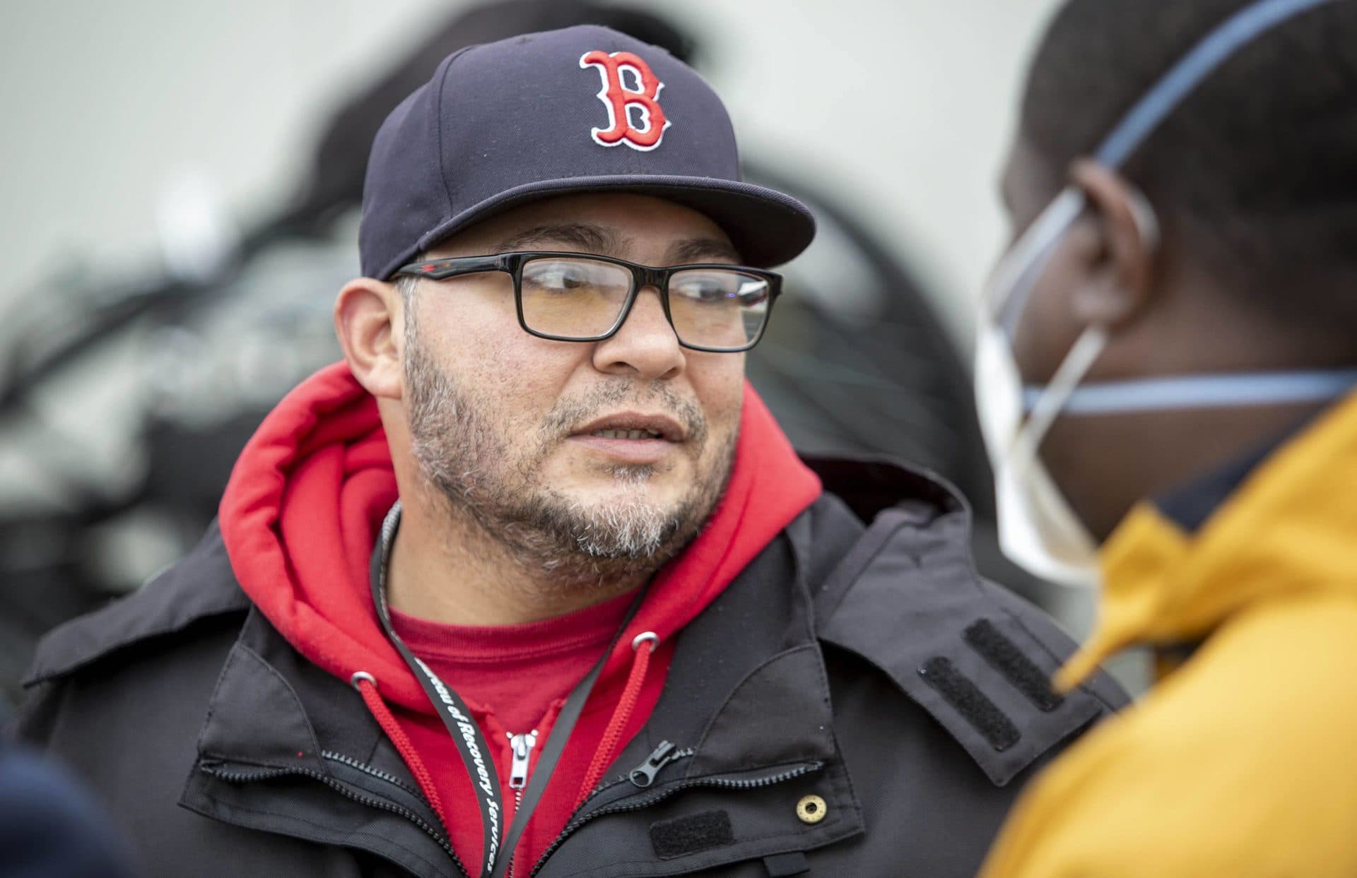 Recovery Services Program Director Mario Chaparro watches as a work crew removes makeshift homeless shelters from the sidewalk on Southampton Street. (Robin Lubbock/WBUR)