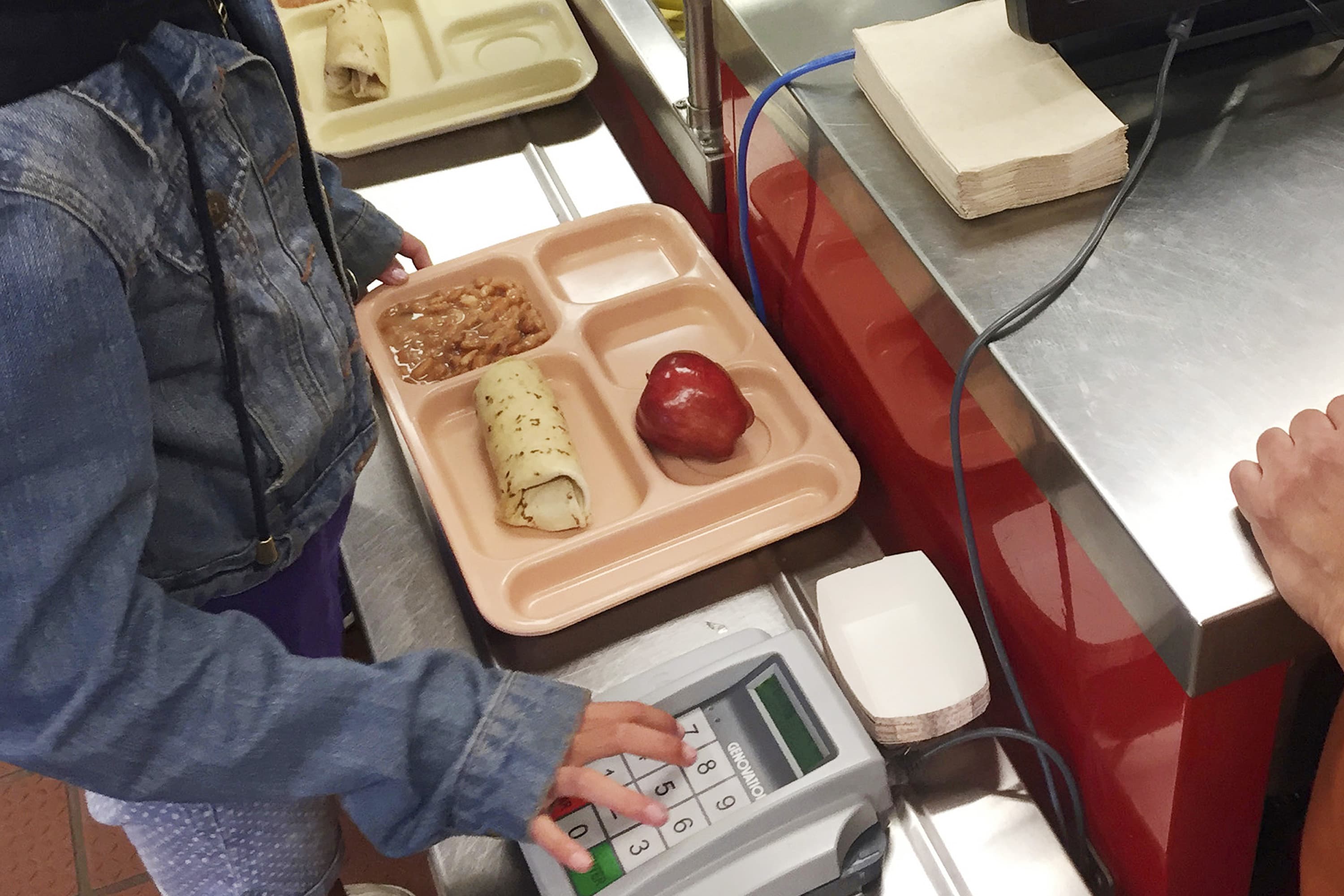 A third-grader punches in her student identification to pay for a meal at school. (Morgan Lee/AP)