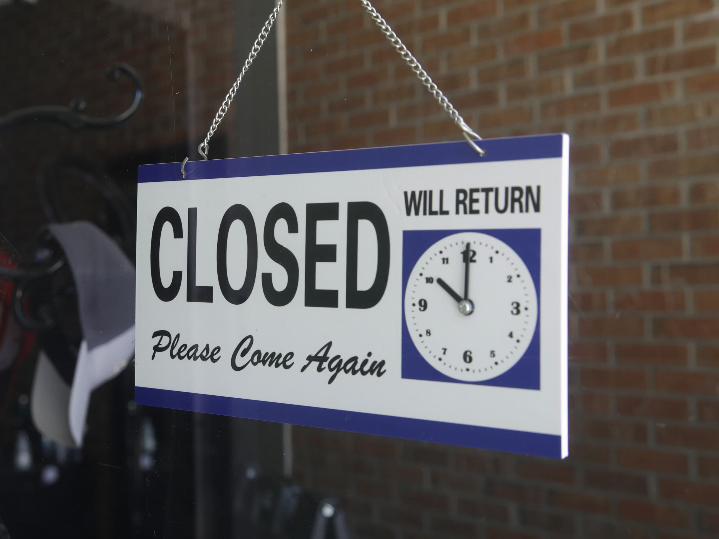 A closed sign hangs in a store window. (Marcio Jose Sanchez/AP)