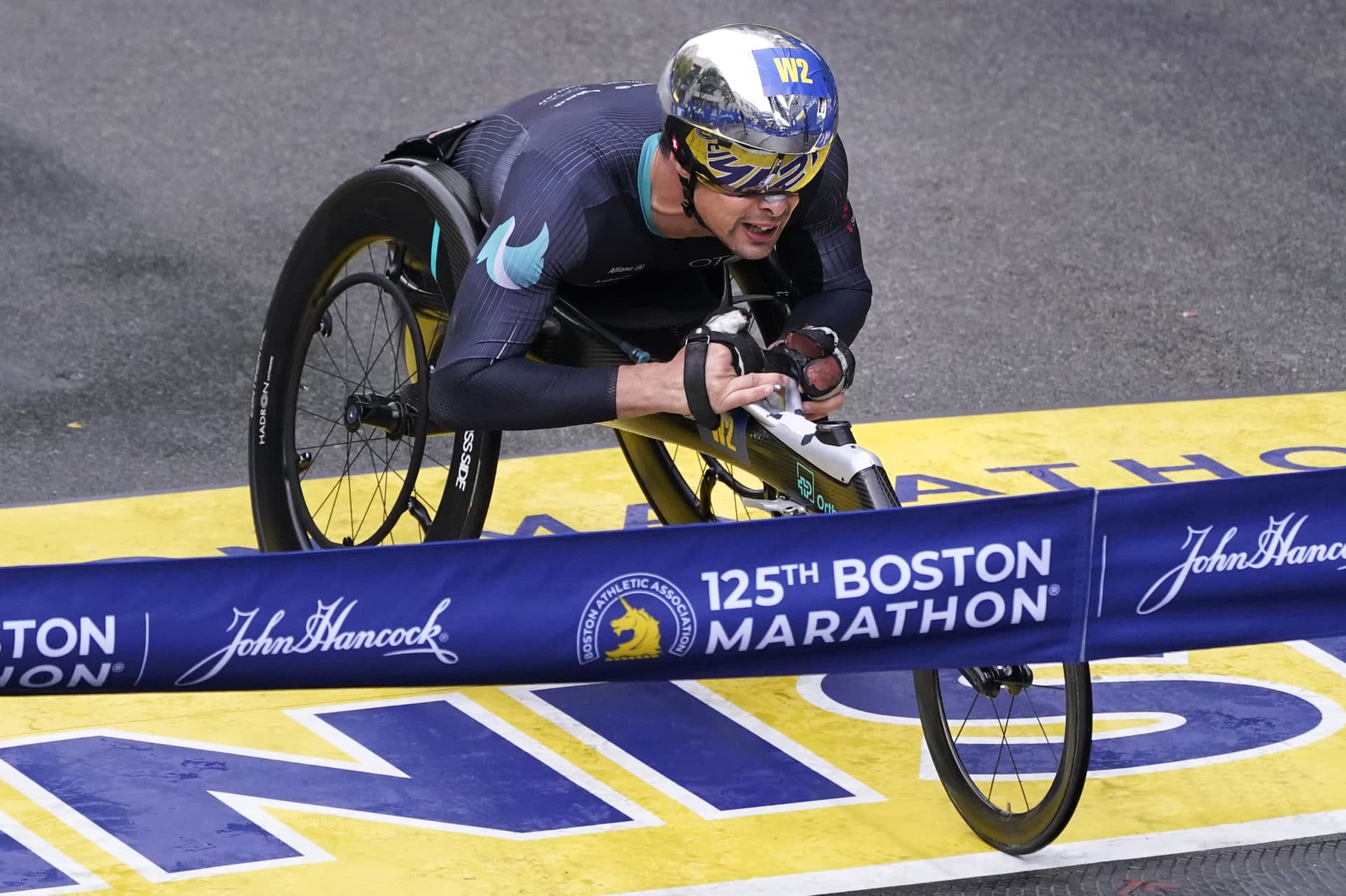Marcel Hug, of Switzerland, rolls across the finish line to win the men's wheelchair division at the Boston Marathon in Boston, Monday, Oct. 11, 2021. (Charles Krupa/AP)