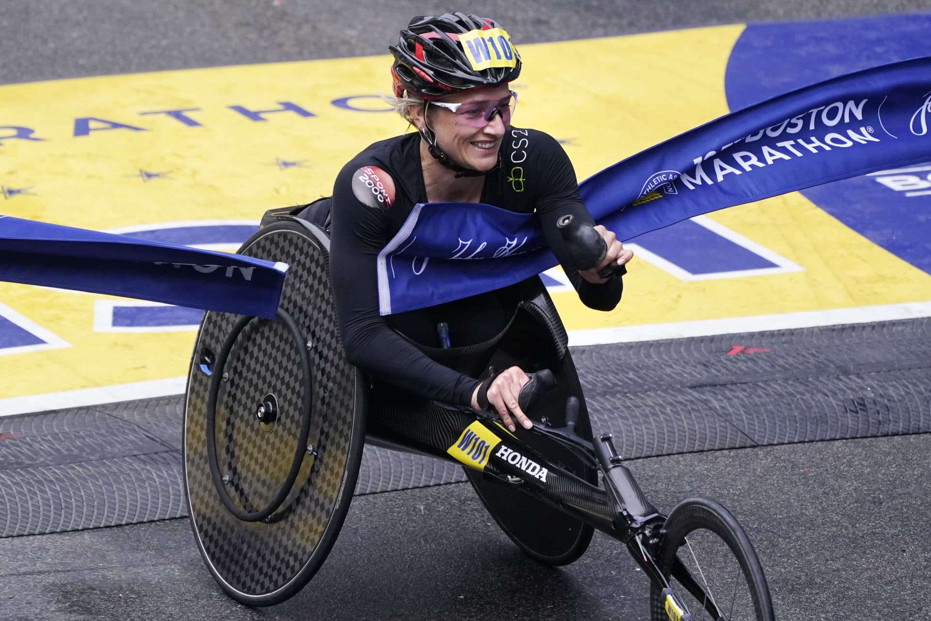 Manuela Schär, of Switzerland, smiles while breaking the finish line to win the women's wheelchair division at the Boston Marathon in Boston, Monday, Oct. 11, 2021. (Charles Krupa/AP)
