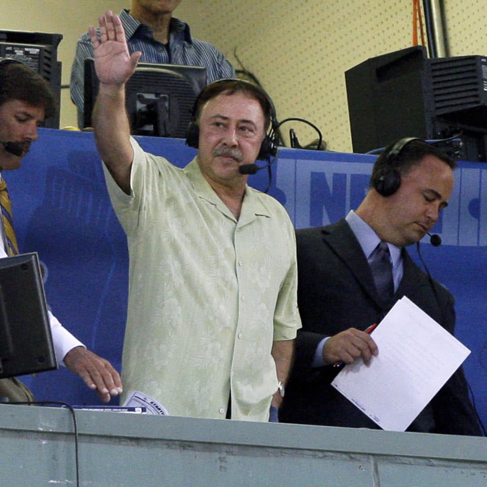 Jerry Remy waves to the crowd from the broadcast booth at Fenway Park during a game against the Detroit Tigers in on Aug. 12, 2009. (Elise Amendola/AP)