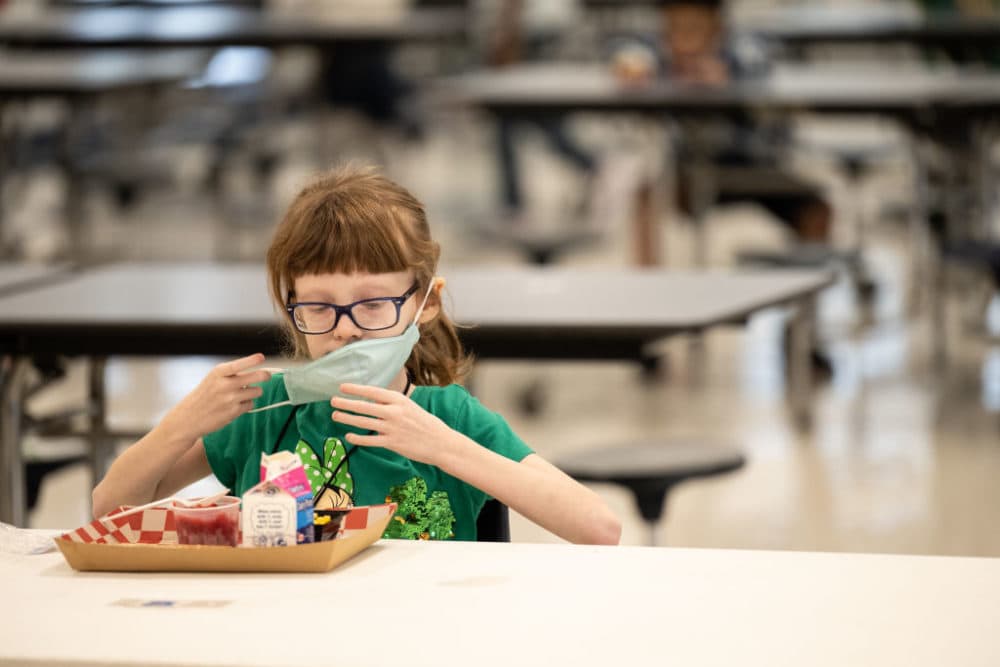 A child puts her mask back on after finishing lunch at a socially distanced table in the cafeteria of Medora Elementary School on March 17, 2021 in Louisville, Kentucky. (Jon Cherry/Getty Images)