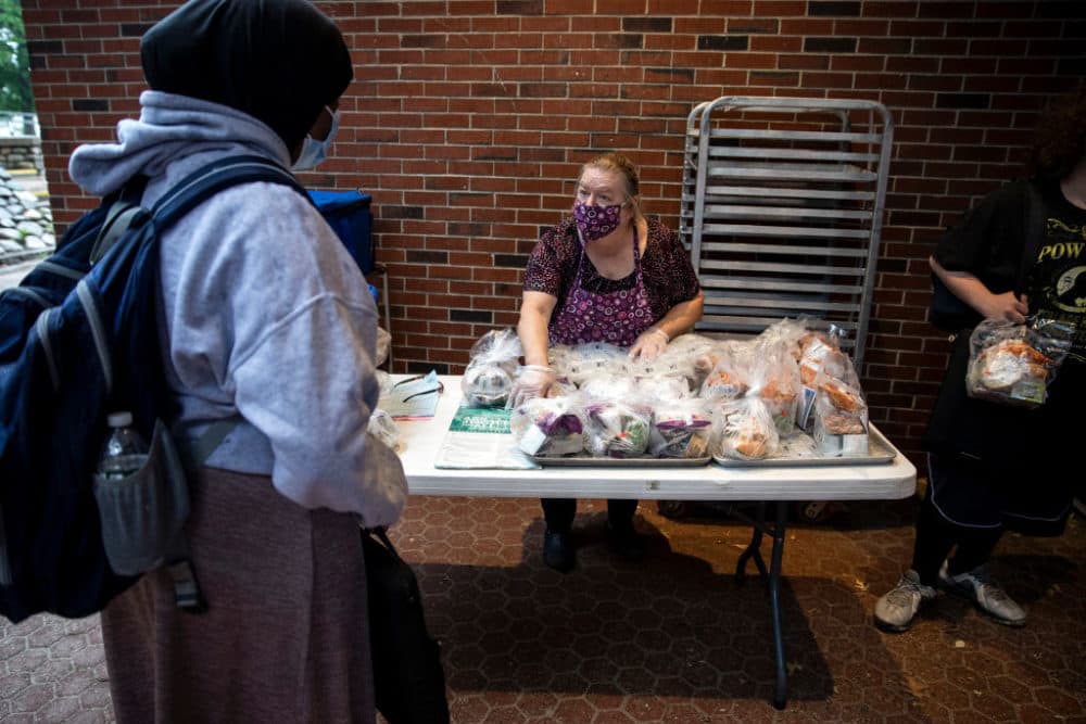 Deborah Jendrasko gives out free lunches for to students at Deering High School on Friday, July 9, 2021. The meals are available to students doing summer programs as well as any children from the community 18 or under. Maine decided to extend free meals during the school year for all students after the coronavirus pandemic is over. (Brianna Soukup/Portland Press Herald via Getty Images)