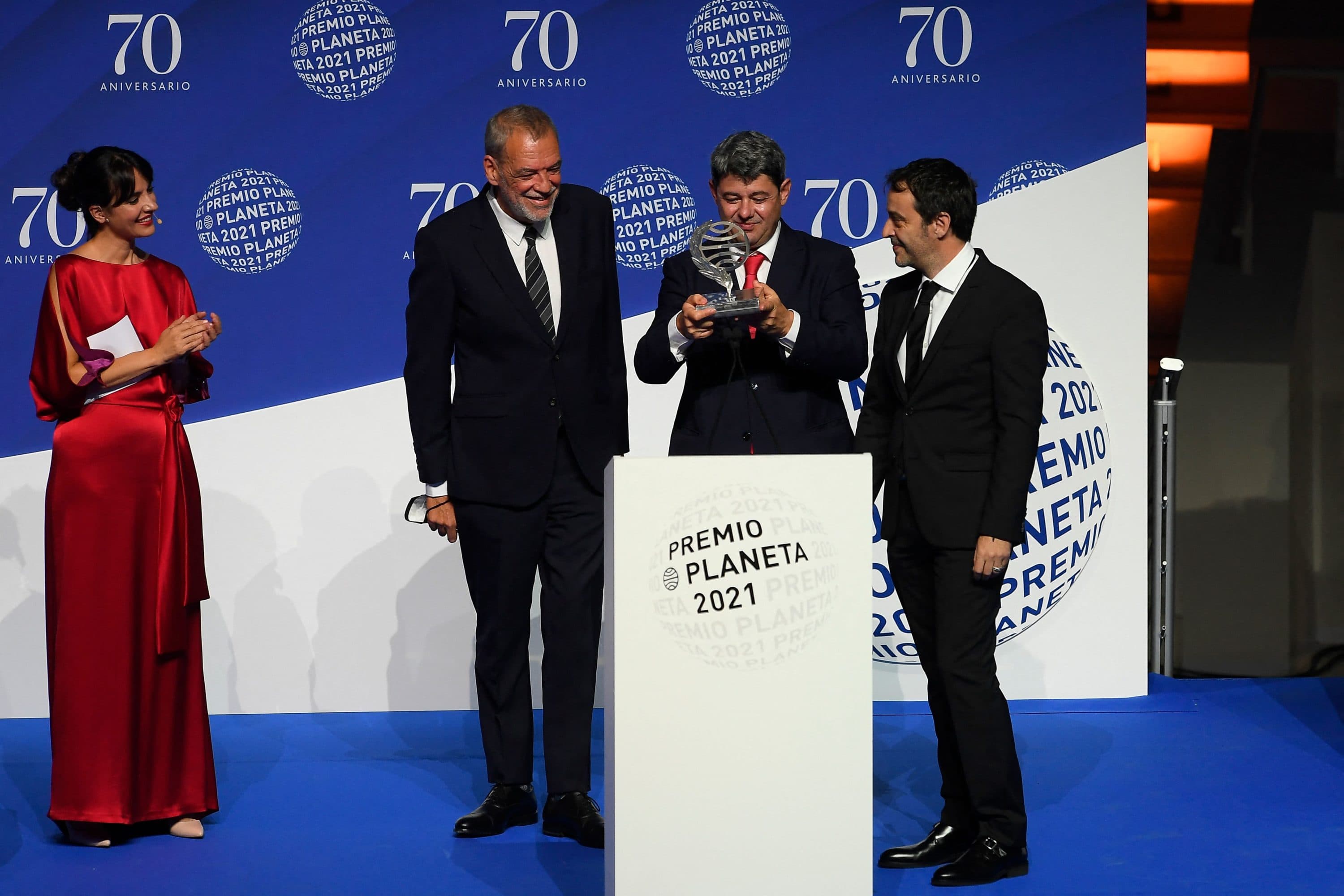 (From 2nd-L) Winners of Spain's 2021 Premio Planeta award Jorge Diaz, Antonio Mercero and Augustin Martinez receive the trophy for their novel "La Bestia", written under the pseudonym Carmen Mola during the ceremony of the 70th edition of the "Premio Planeta" award, in Barcelona on Oct. 15, 2021. (Josep Lago/AFP via Getty Images)