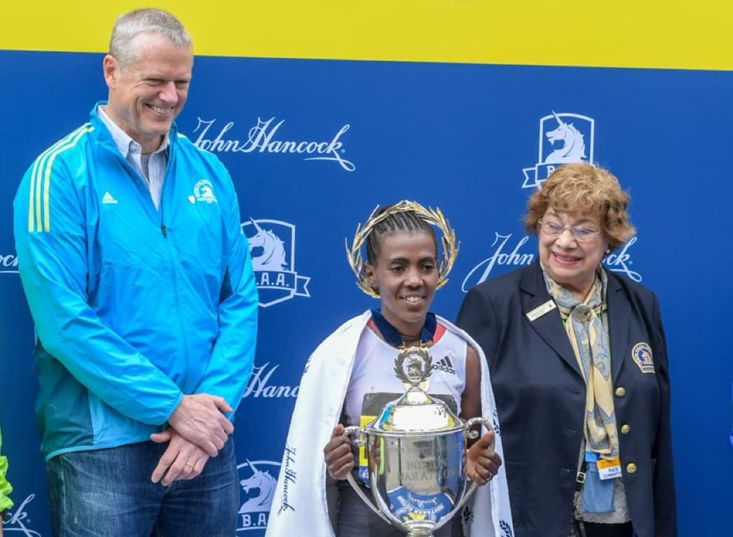 Gloria Ratti (R) with Boston Marathon winner Worknesh Degefa and Gov. Charlie Baker at the finish line in 2019. (Courtesy Boston Athletic Association)
