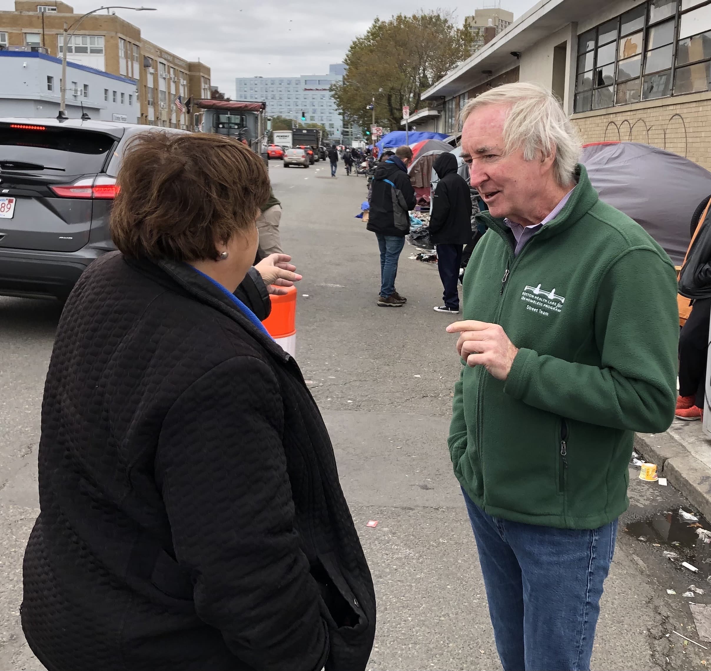 Dr. Jim O’Connell, president of Boston Health Care for the Homeless Program, talks with Sue Sullivan, executive director of the Newmarket Business Association, who approached him to ask about his thoughts on the homelessness crisis. (Lynn Jolicoeur/WBUR)