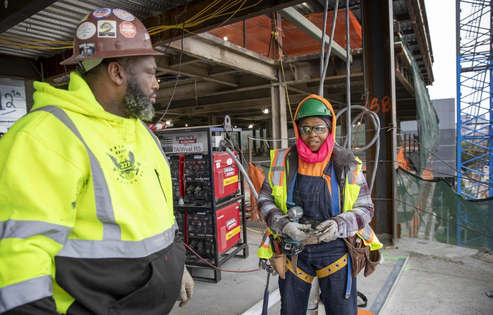 Eyoda Williams, a first-year apprentice, and Glenn Cofield, a carpenter's steward with Local 327, talk at a construction site in Boston. (Robin Lubbock/WBUR)