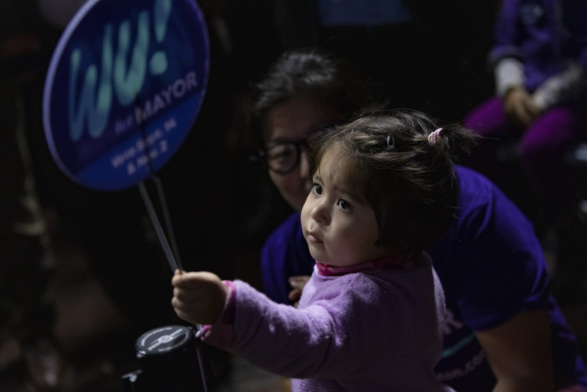 Two-year-old Emily Li-Nagy holds a "Wu for Mayor" sign at the Michelle Wu election night party at the Cyclorama. (Jesse Costa/WBUR)