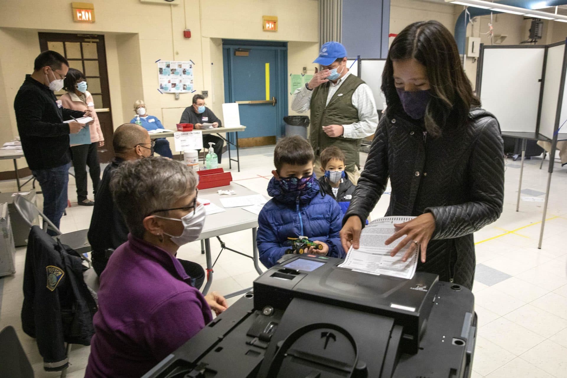 Michelle Wu casts her ballot with her family at the Phineas Bates Elementary School in Roslindale. (Robin Lubbock/WBUR)