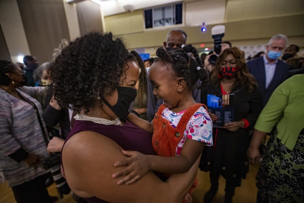 Acting Mayor Kim Janey embraces 3-year-old Jnenaih Shingr after giving her farewell remarks at Hibernian Hall in Roxbury. (Jesse Costa/WBUR)