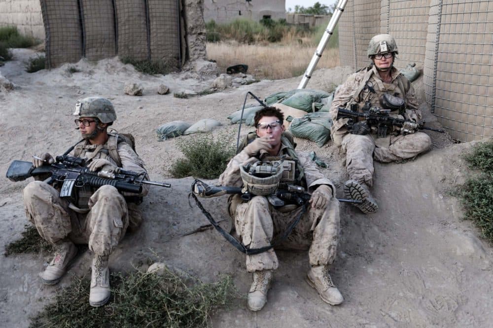 Third Squad Marines take a smoke break at the entrance to Patrol Base Fires, their home in Sangin, Afghanistan. From left to right: Corporal Michael Dutcher, who was killed on September 15, 2011; Lance Corporal John Bohlinger, the squad's radio operator; and Hospitalman Matthew Foreit, the squad's Navy corpsman. (Elliott Woods)