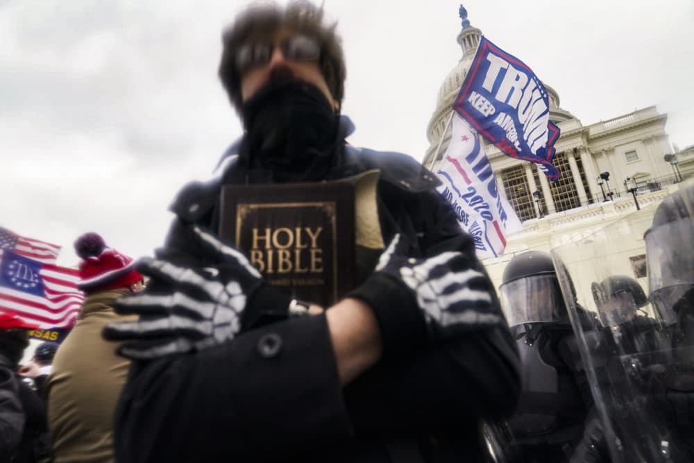 A man holds a Bible as Trump supporters gather outside the Capitol in Washington. (John Minchillo/AP Photo)