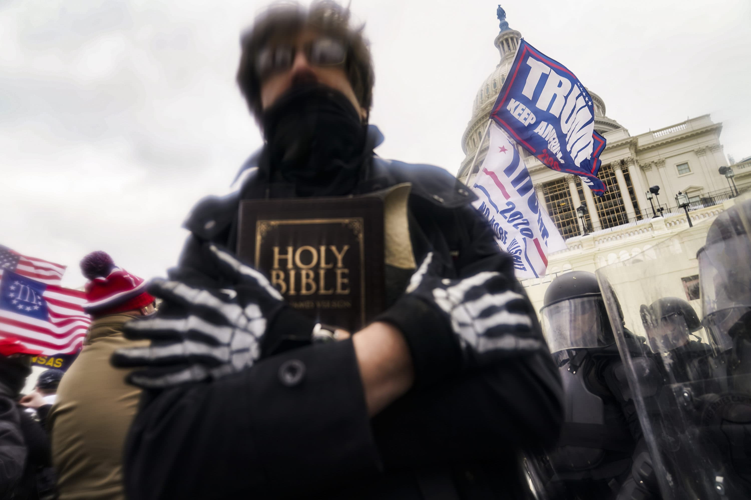 A man holds a Bible as Trump supporters gather outside the Capitol in Washington. (John Minchillo/AP Photo)