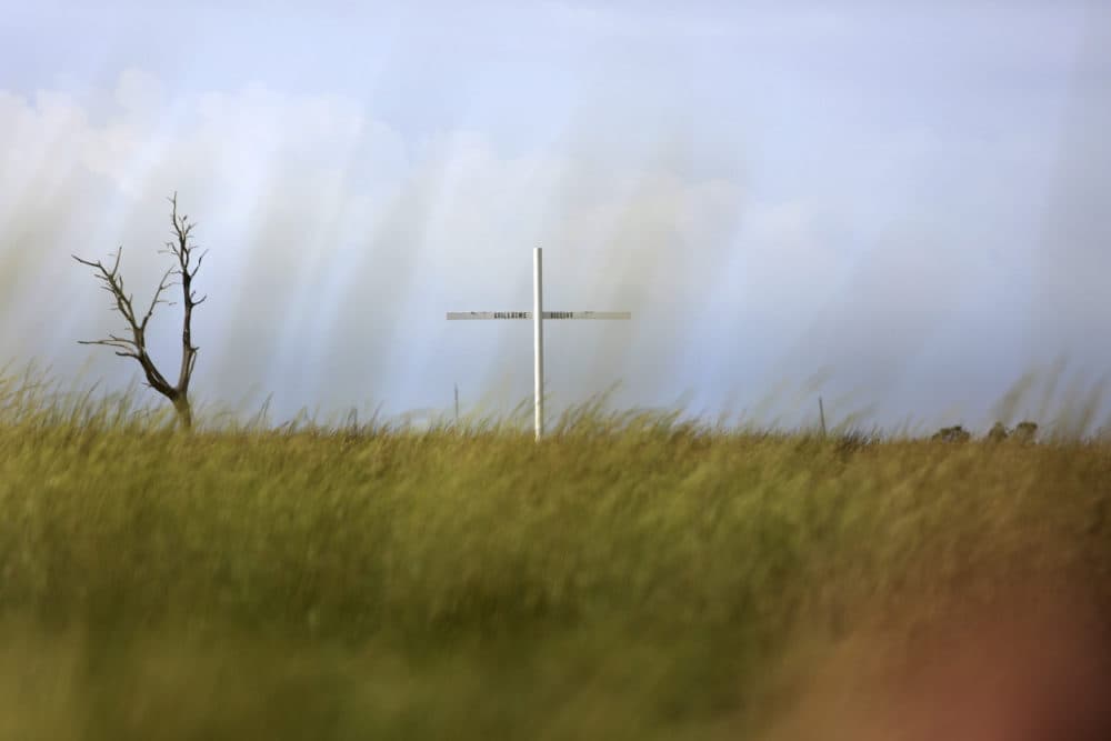 A cross marks one of several Pointe-au-Chien Indian Tribe burial grounds along Bayou Pointe-au-Chien in southern Louisiana on Wednesday, Sept. 29, 2021. The cemetery is one of many sacred grounds the local community is trying to save from coastal erosion and sea level rise. (Jessie Wardarski/AP)
