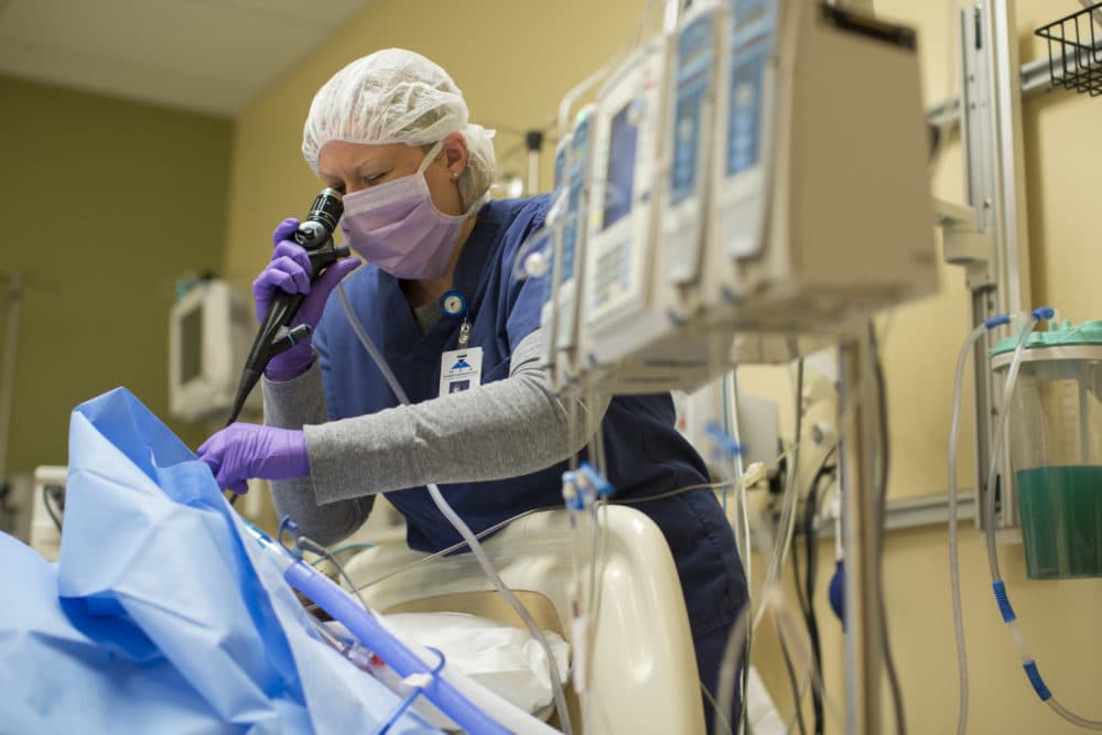 An organ procurement coordinator performs a bronchoscopy and removes mucus from the lungs of an organ donor at Mid-America Transplant Services in St. Louis. (Whitney Curtis/AP)
