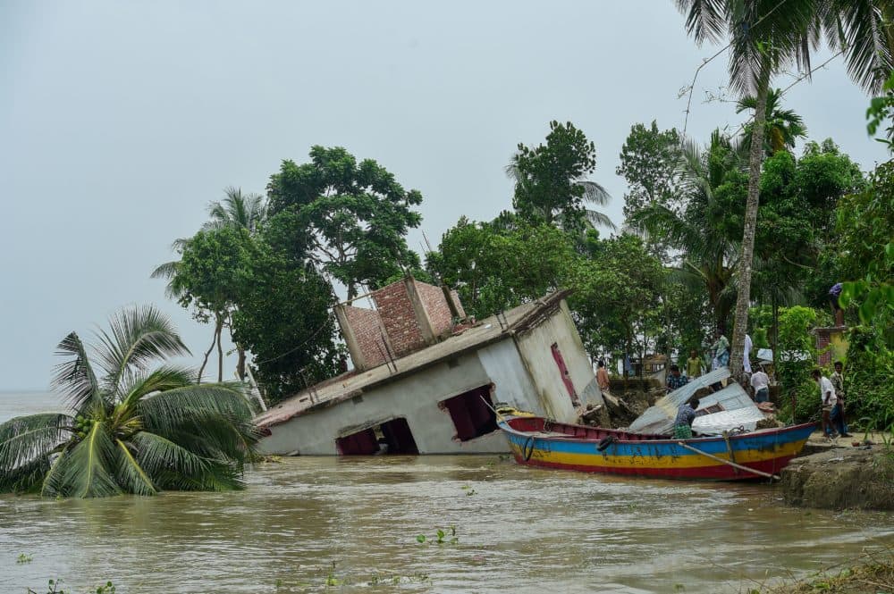 A partially collapsed house stands on the banks of the Padma River after aggressive erosion of land close to the river in Bangladesh. (MUNIR UZ ZAMAN/AFP via Getty Images)