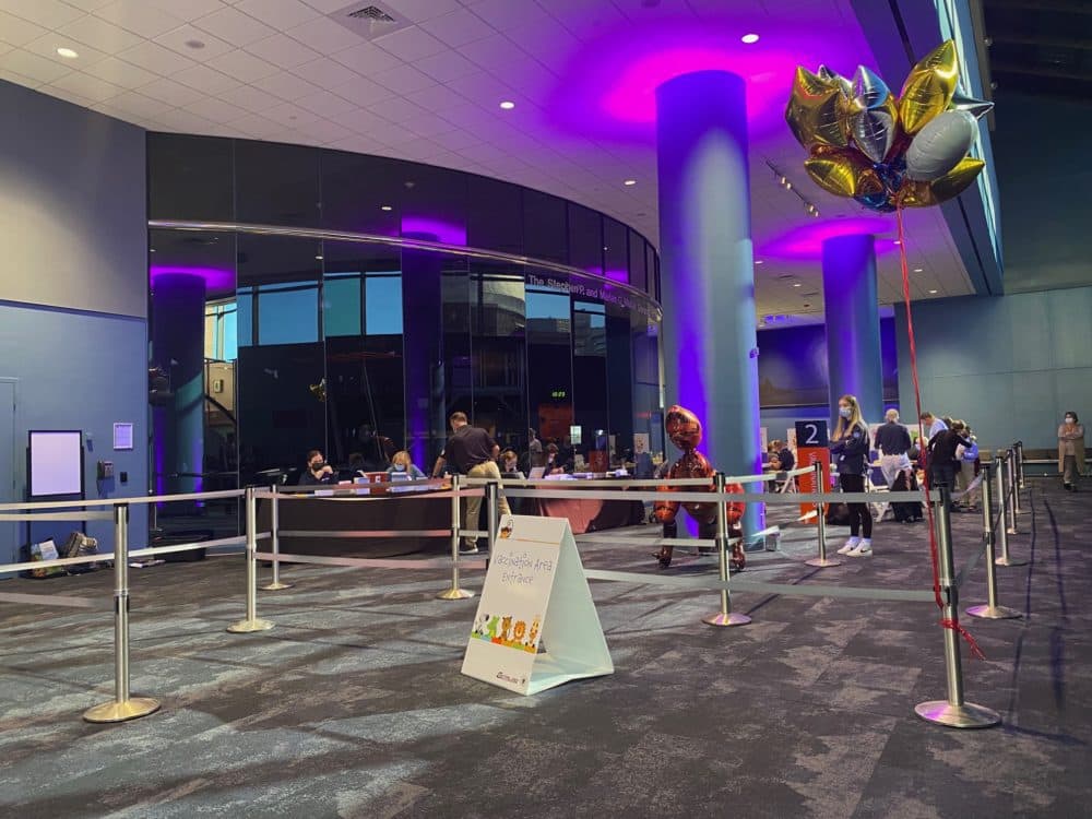 A vaccine clinic is set up between the IMAX theater and the planetarium inside the Museum of Science this weekend. (Amanda Beland/WBUR)