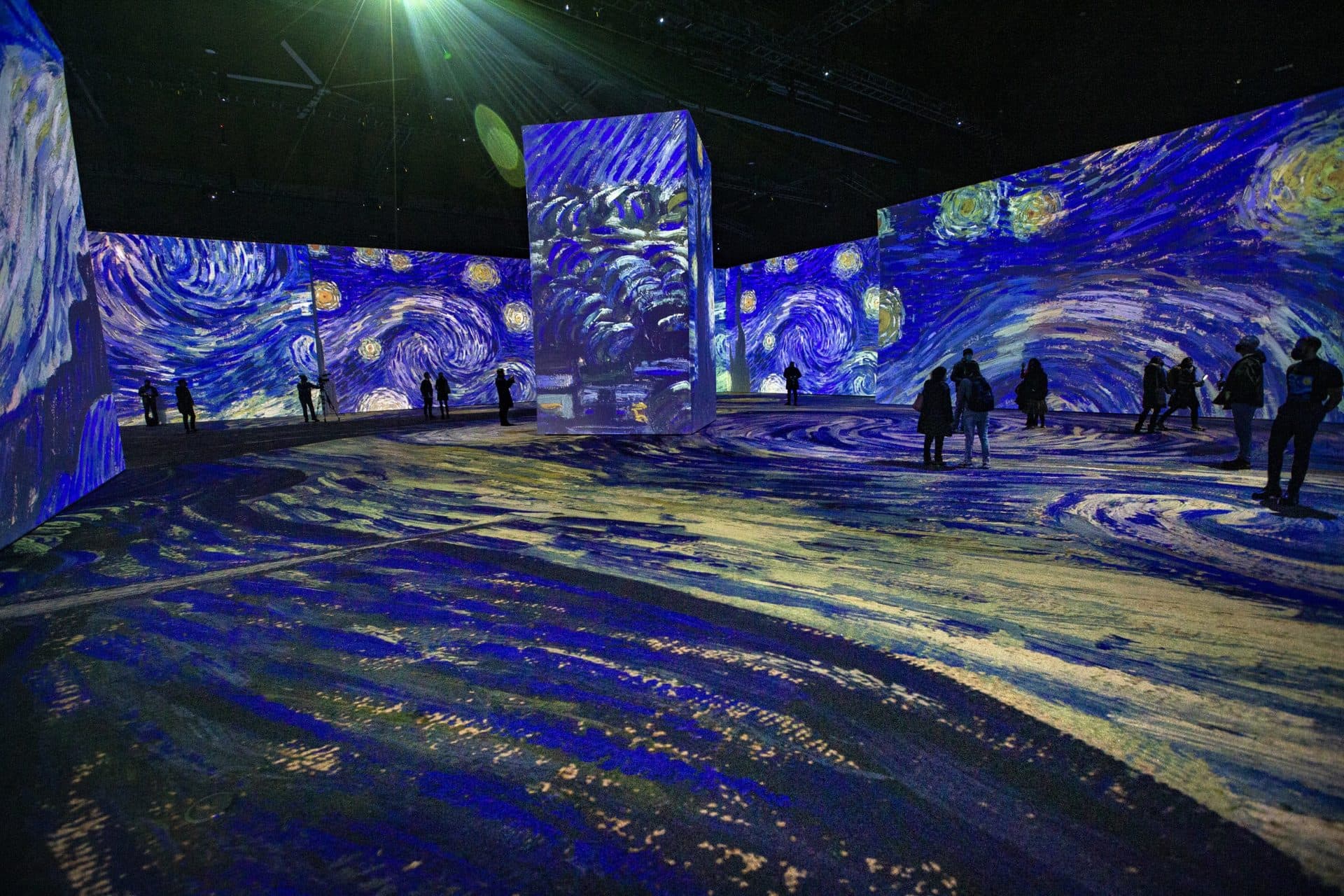 Projections of Vincent van Gogh’s &quot;The Starry Night&quot; flood the walls and floor and surround members of the media as they experience the press preview of “Imagine Van Gogh” at the SoWa Power Station in the South End. (Jesse Costa/WBUR)