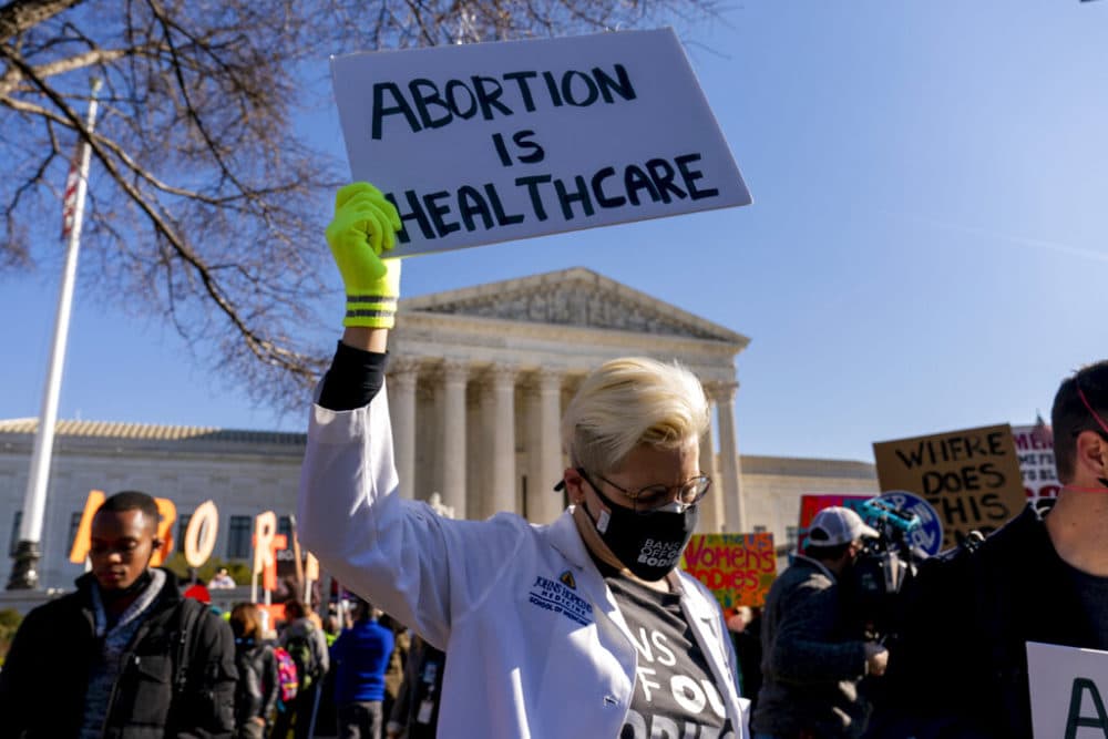 FILE - A woman holds a poster that reads &quot;Abortion is Healthcare&quot; as abortion rights advocates and anti-abortion protesters demonstrate in front of the U.S. Supreme Court, Dec. 1, 2021, in Washington, as the court hears arguments in a case from Mississippi, where a 2018 law would ban abortions after 15 weeks of pregnancy, well before viability. As the Supreme Court court weighs the future of the landmark 1973 Roe v. Wade decision, a resurgent anti-abortion movement is looking to press its advantage in state-by-state battles while abortion-rights supporters prepare to play defense. (AP Photo/Andrew Harnik, File)