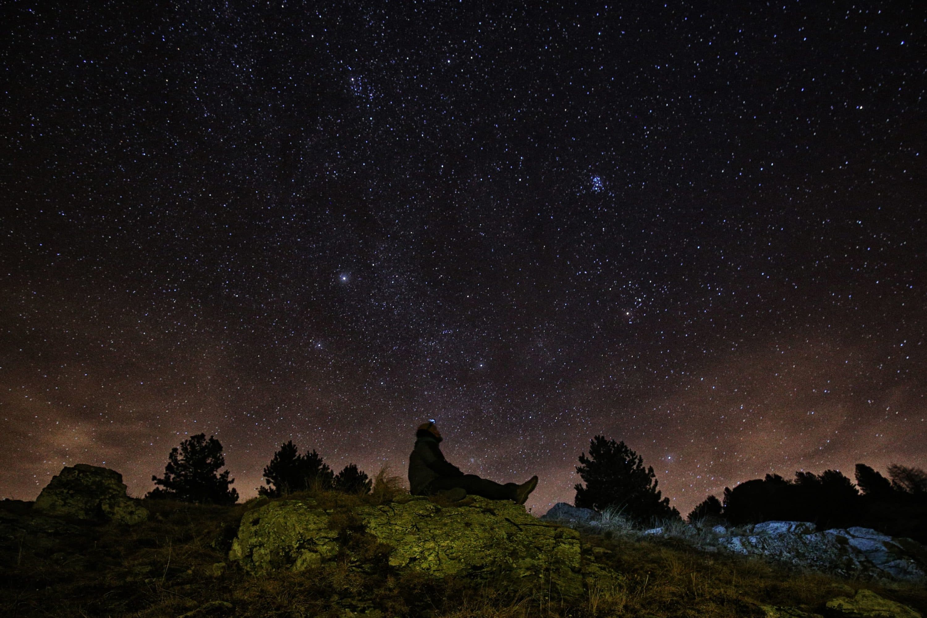 A photographer looks at the sky at night to see the annual Geminid meteor shower on the Elva Hill, in Maira Valley, near Cuneo, northern Italy on Dec. 12, 2015. (Marco Bertorello/AFP via Getty Images)