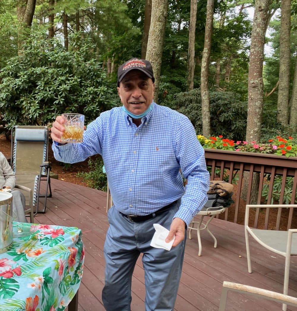 The author's father raising his glass with a boisterous "cheers!" at an outdoor gathering with friends in Rhode Island, Summer 2020. (Courtesy of Noreen Wasti)