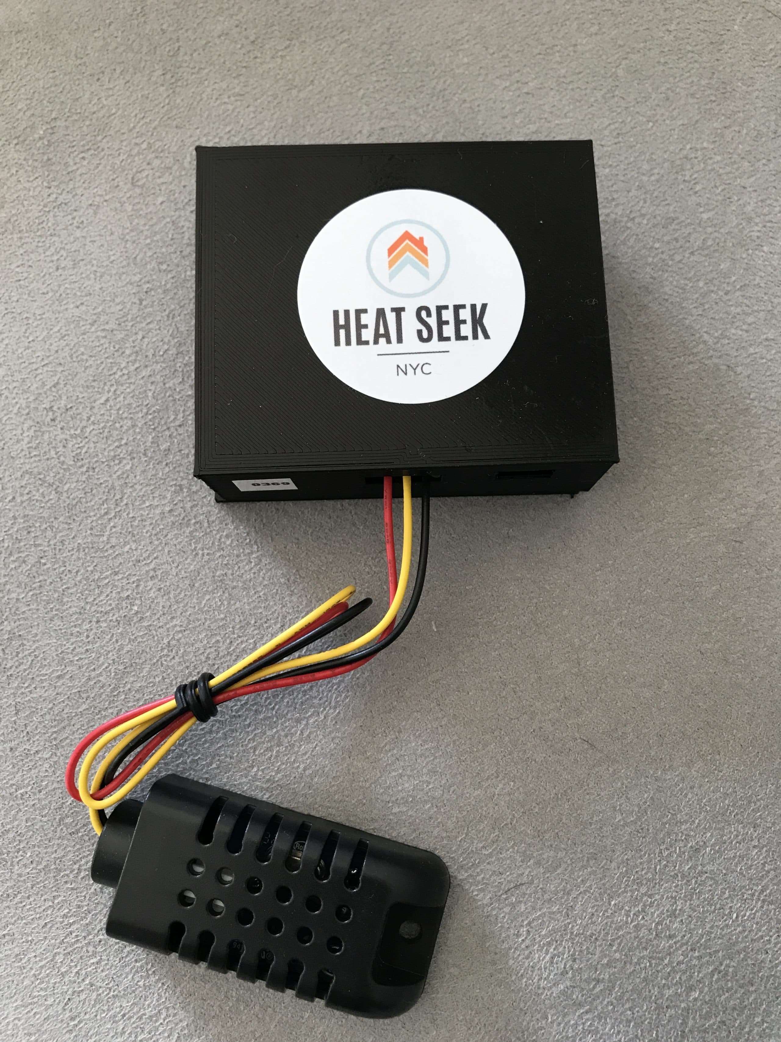 The circuitry for the Heat Seek sensor is contained in a plastic box (shown here with the Heat Seek logo on it) that is half the size of a deck of playing cards. Its thermometer is housed in a smaller, separate unit about the size of a human thumb. (Courtesy of Heat Seek)