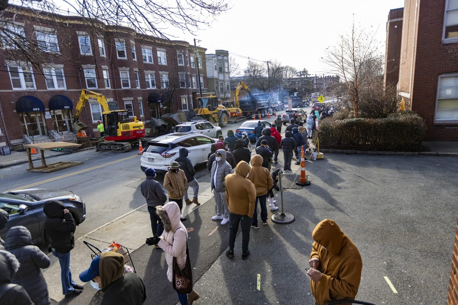 A very long line of people waiting to receive COVID-19 tests stretches down Broadway in Chelsea. (Jesse Costa/WBUR)