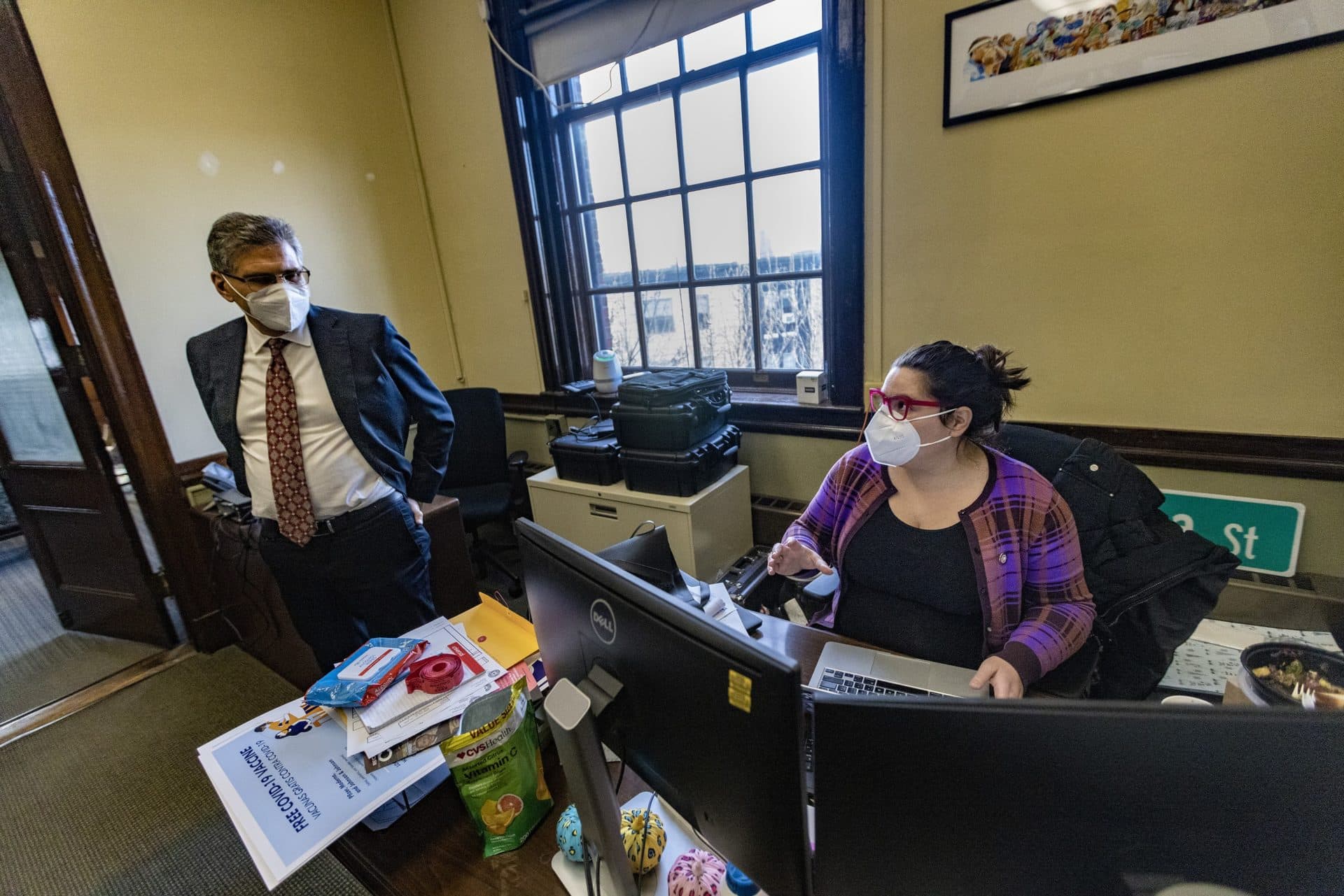 Chelsea City Manager Tom Ambrosino, left, checks in with Communication and Community Outreach Manager Lourdes Alvarez after her visit to the COVID-19 clinic at the St. Rose School. (Jesse Costa/WBUR)
