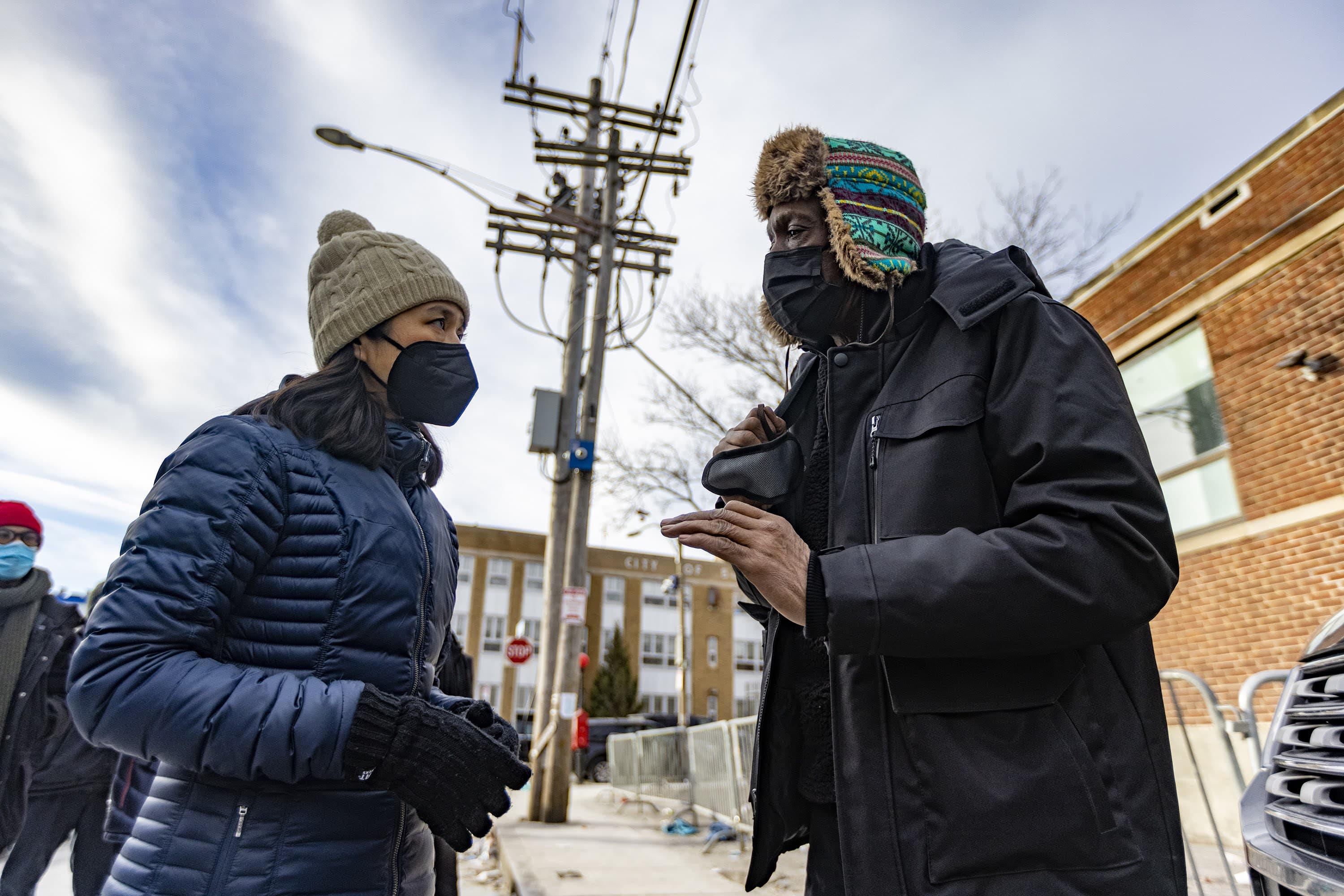 Mayor Michelle Wu speaks with Norris Cowart who has been in and out of the Southampton Street Shelter, about the current conditions on Atkinson street and the possibility to get affordable housing. (Jesse Costa/WBUR)