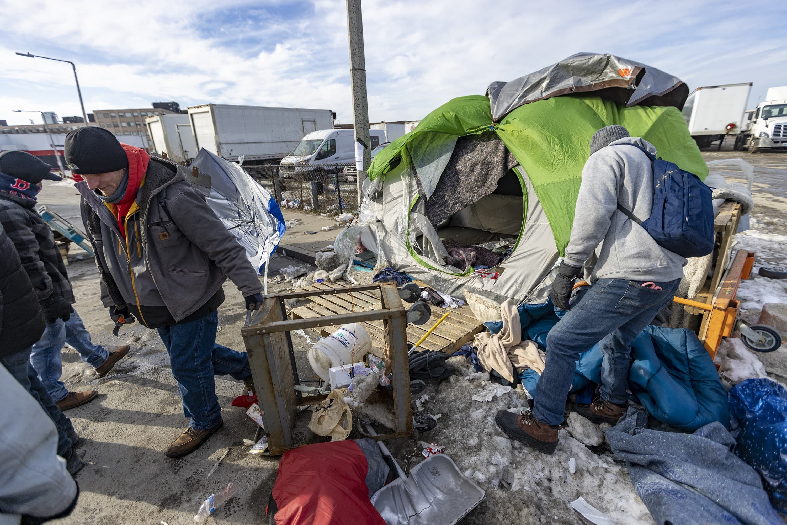 Volunteer shelter workers dismantle a homeless tent dwelling at the Newmarket Triangle. (Jesse Costa/WBUR)