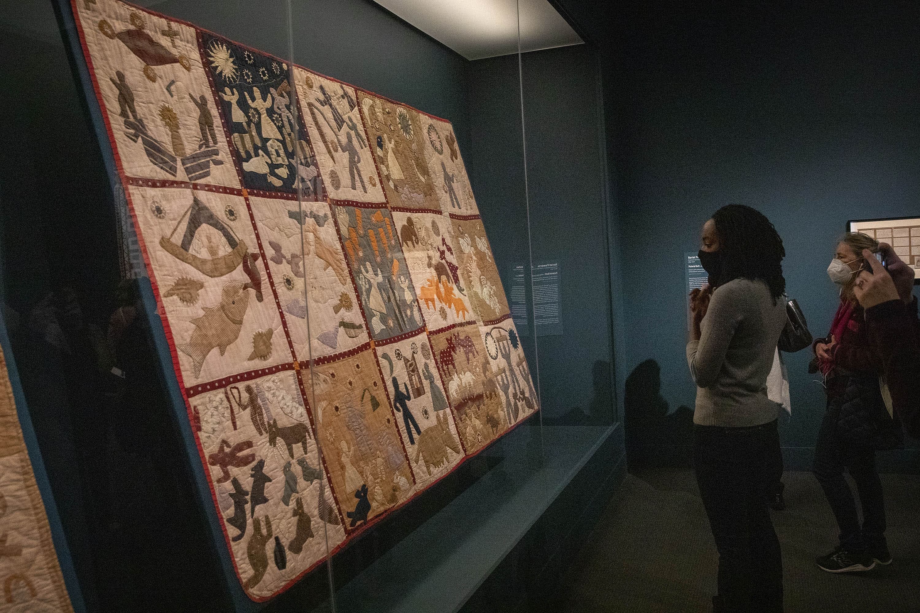 Alyse Minter, a descendent of Harriet Powers, contemplates Powers' Pictorial Quilt on display in the MFA's exhibit &quot;Fabric of a Nation: American Quilt Stories.&quot; (Robin Lubbock/WBUR)