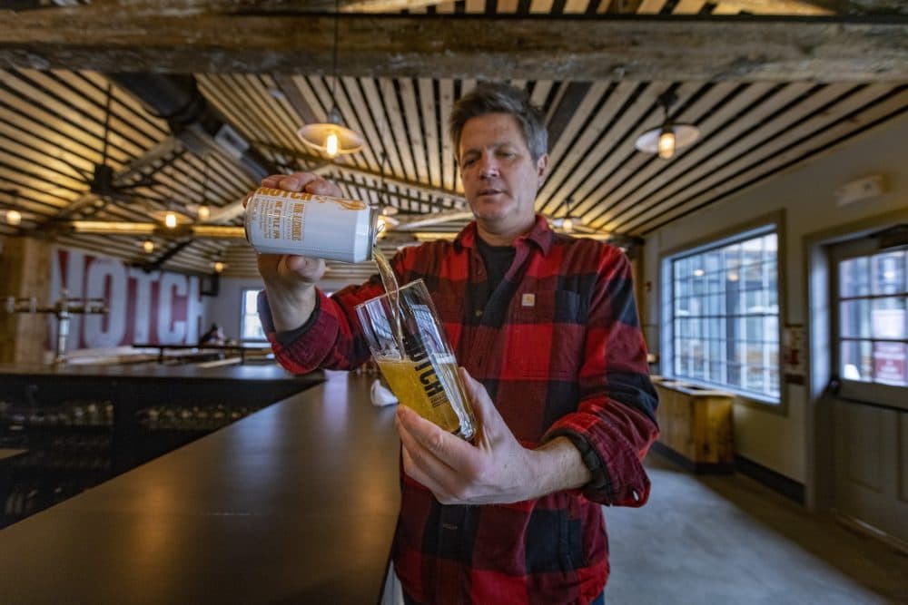 Notch Brewing owner and brewer Chris Lohring pours a nonalcoholic version of their New England IPA into a glass at the taproom at the Speedway in Brighton. (Jesse Costa/WBUR)