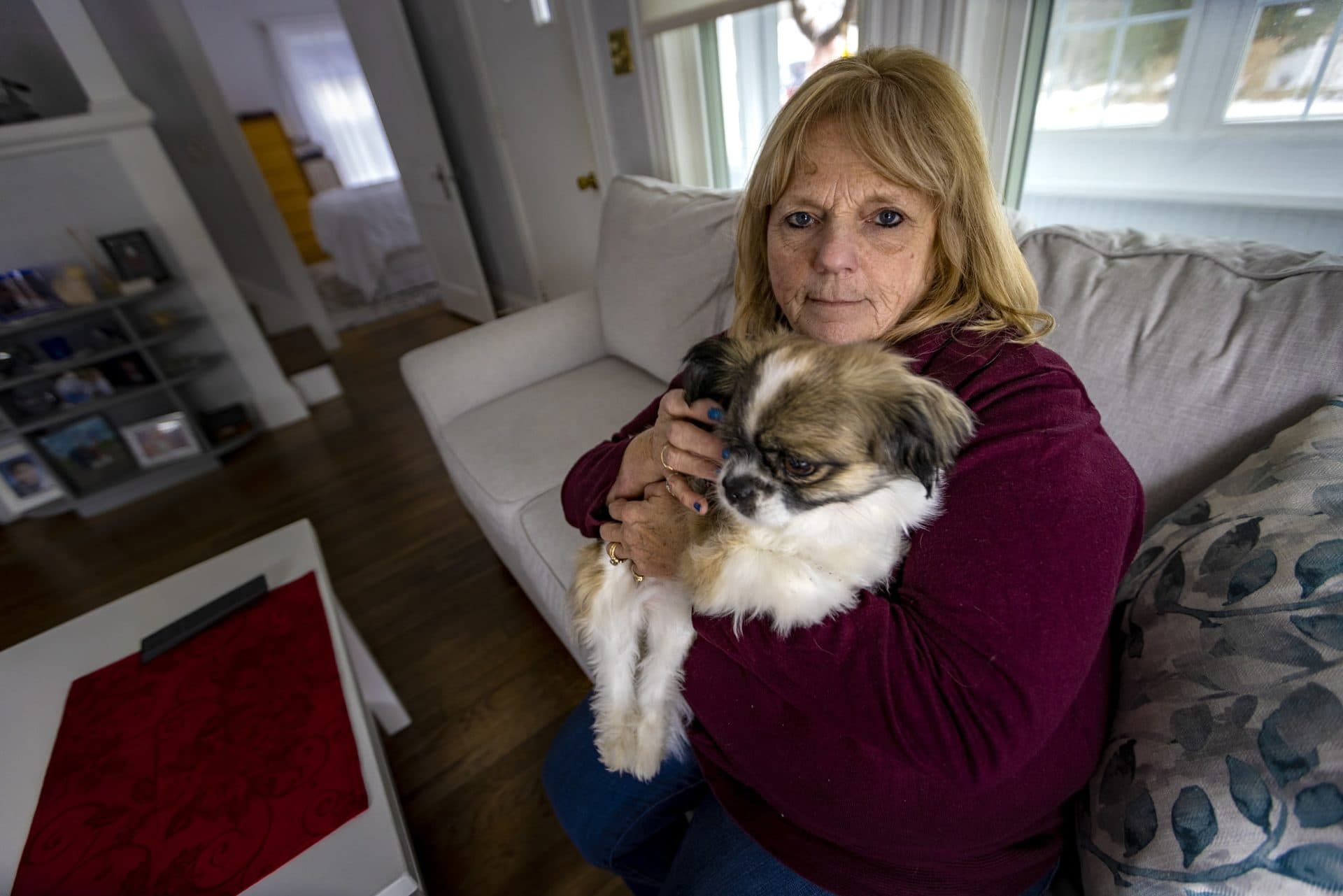 Patti Parent holding her dog Roxie at her home. (Jesse Costa/WBUR)