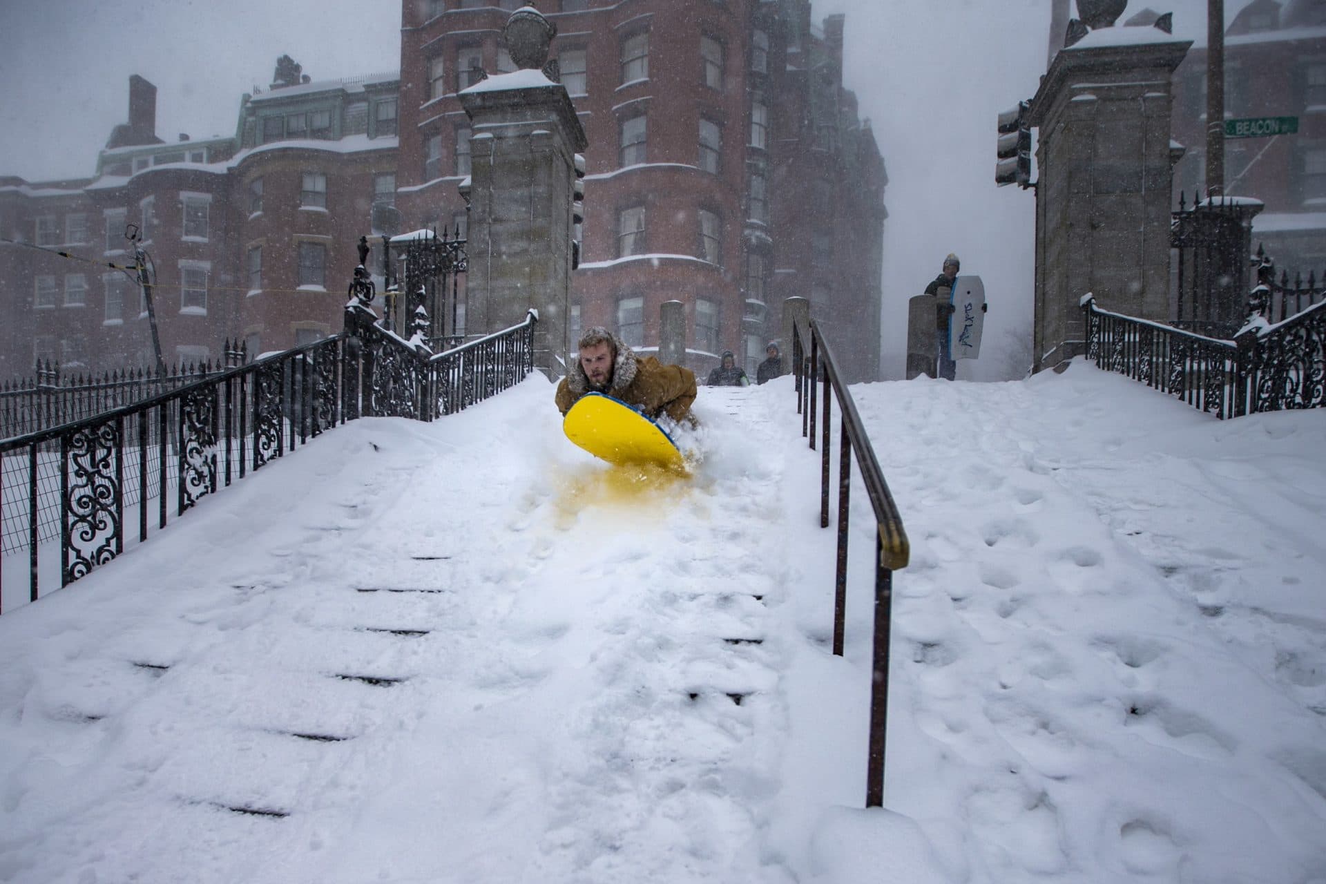A Suffolk Law student gets some air as he sleds down the snow covered steps leading into the Boston Common. (Jesse Costa/WBUR)