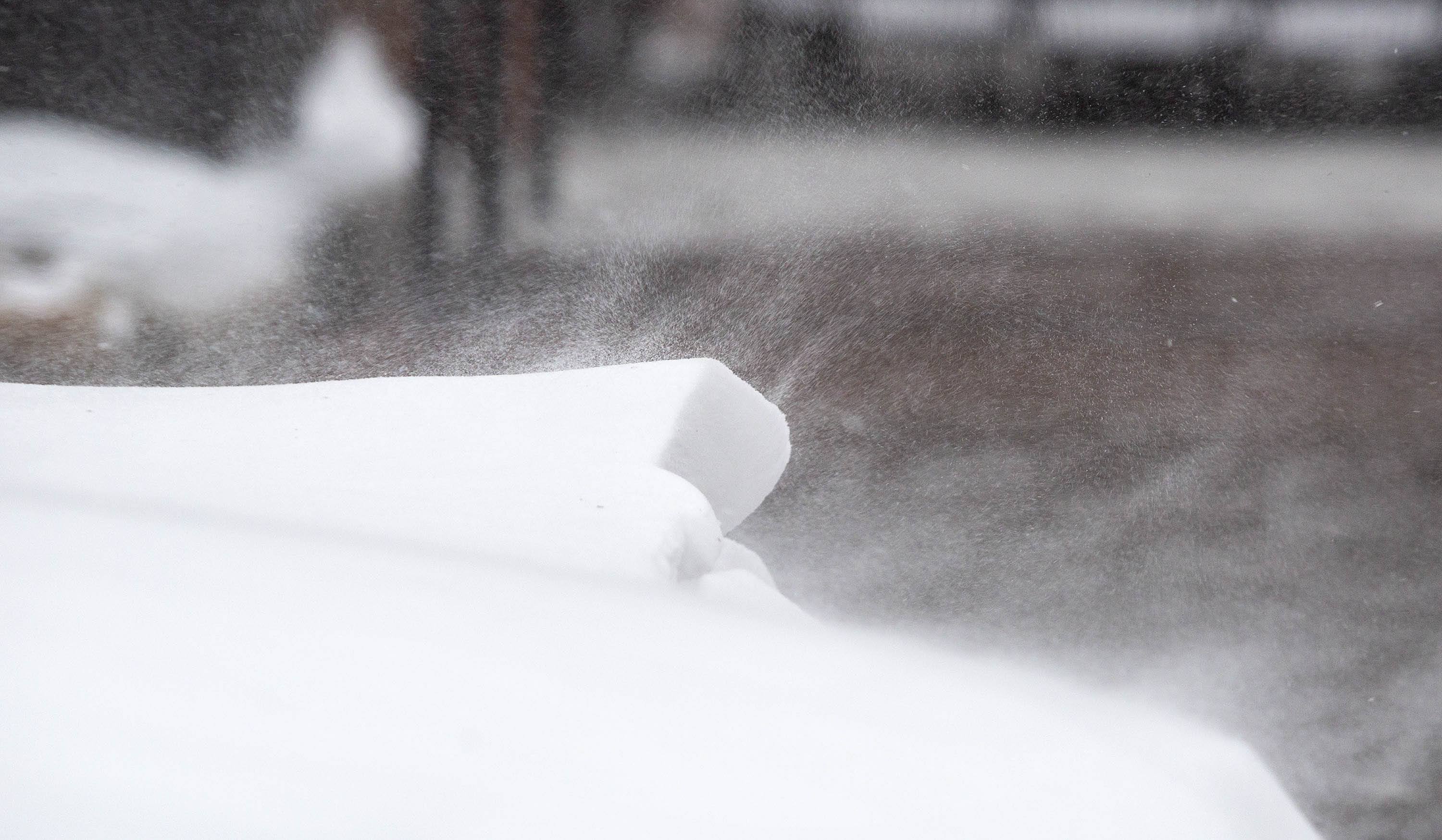 A gust of wind sends s flurry of snow off a snow bank on Long Wharf. (Robin Lubbock/WBUR)