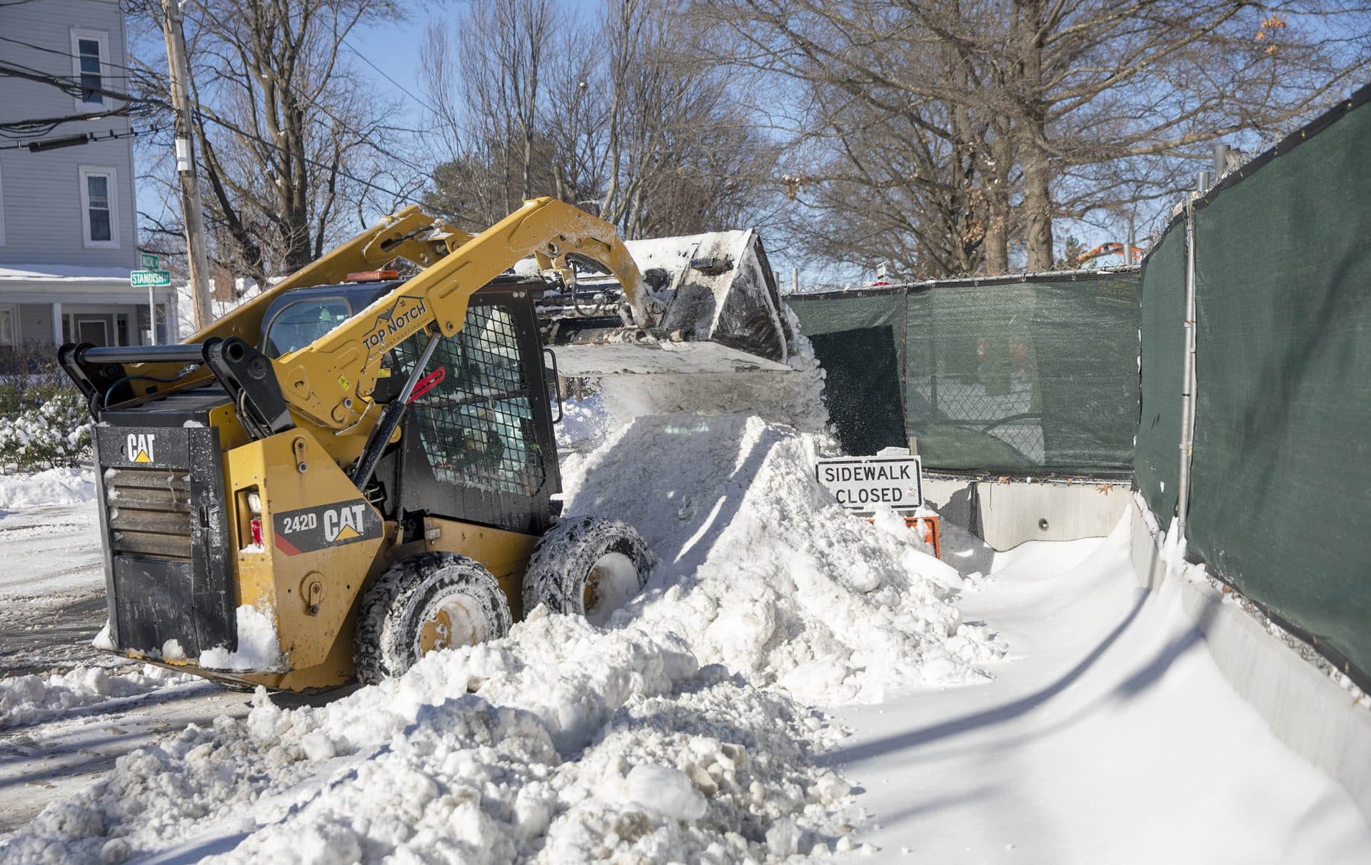 A skid-steer loader moves snow off the streets in Cambridge. (Robin Lubbock/WBUR)