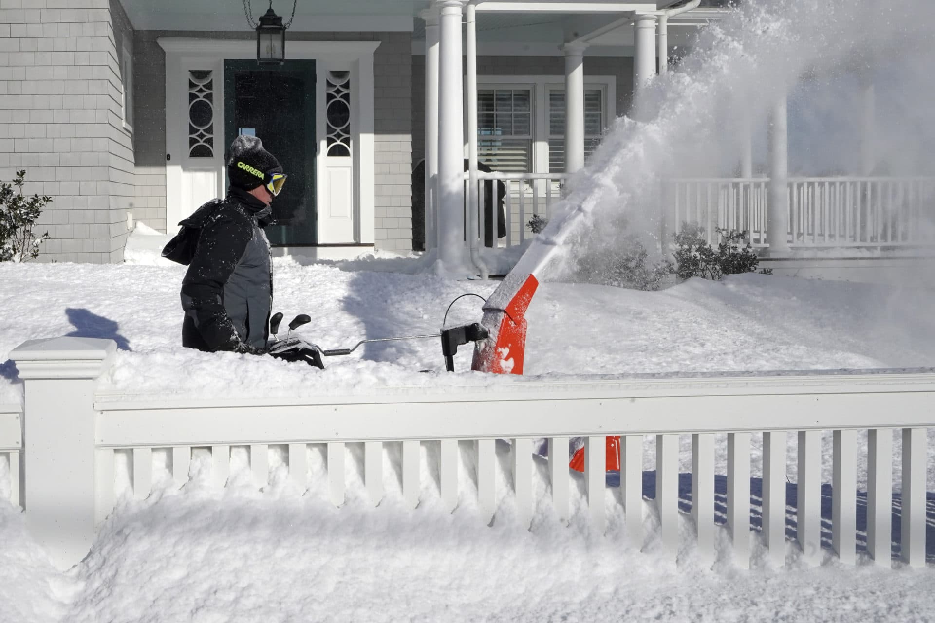 Bill McKelvey, of Scituate, uses a snow blower to clear snow in front of his home, Sunday, Jan. 30, 2022. (Steven Senne/AP)