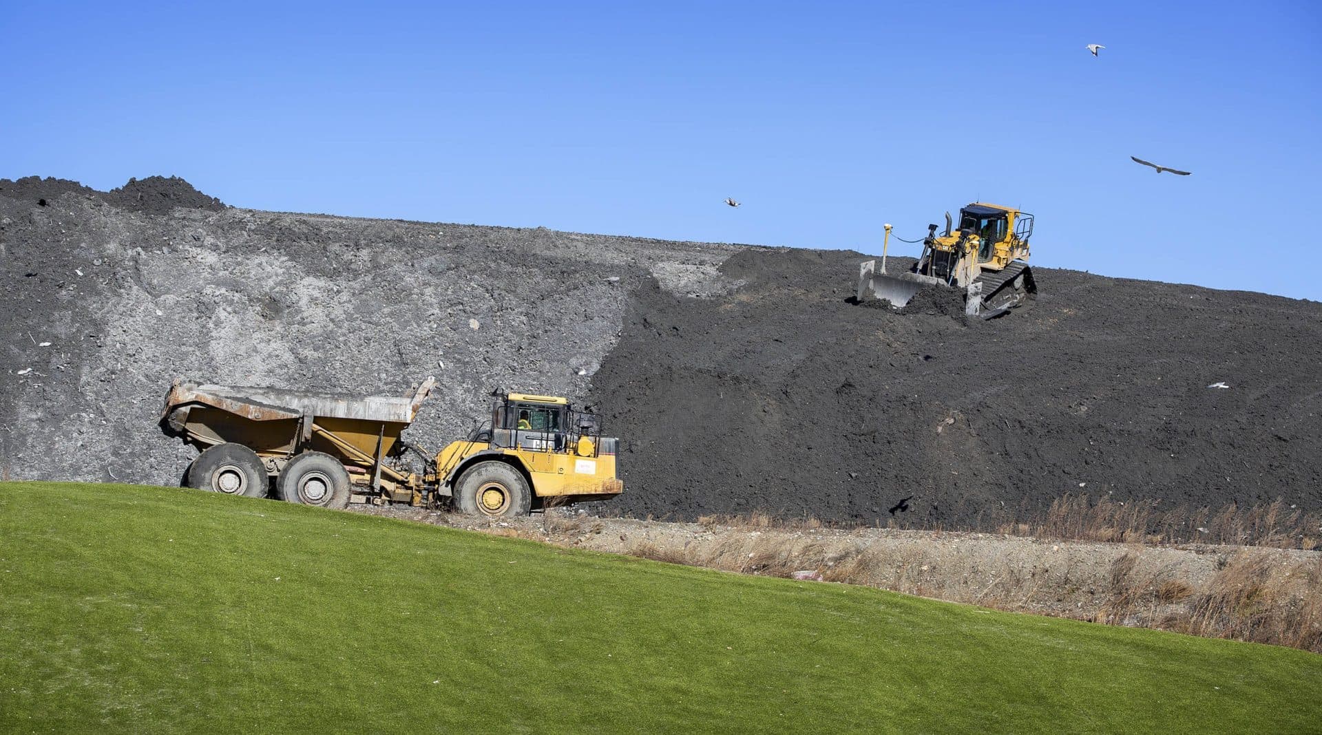 A bulldozer levels ash on a landfill mound beside Covanta's Haverhill waste facility that incinerates trash and generates electricity. (Robin Lubbock/WBUR)