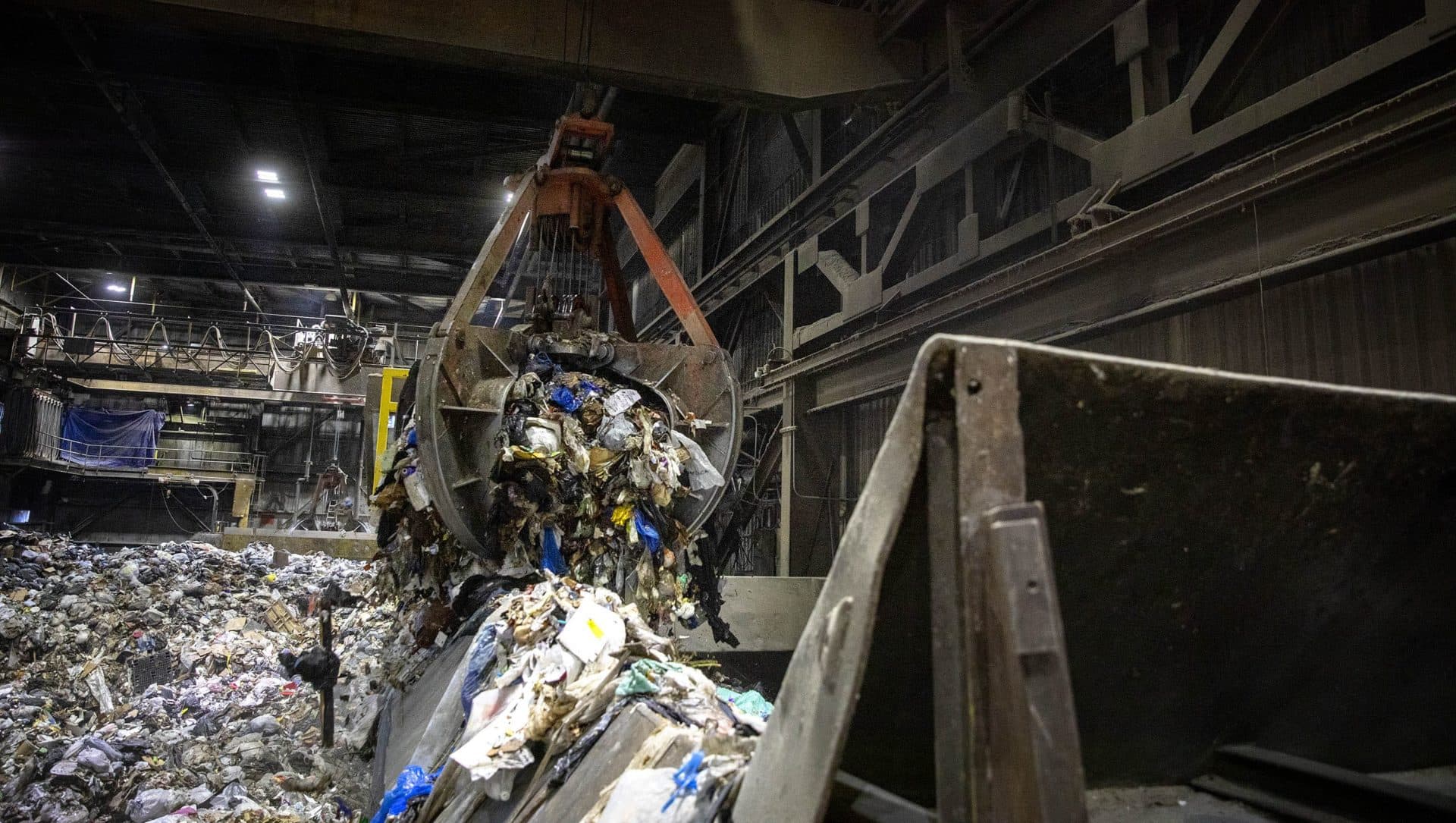 A crane drops garbage into the shoot leading to the incinerator, at Covanta's Haverhill waste facility. (Robin Lubbock/WBUR)