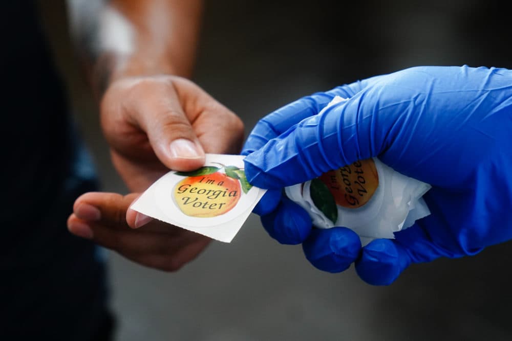 A man receives an &quot;I'm a Georgia Voter&quot; sticker after casting a ballot in Georgia's Primary Election on June 9, 2020 in Atlanta, Georgia. (Elijah Nouvelage/Getty Images)