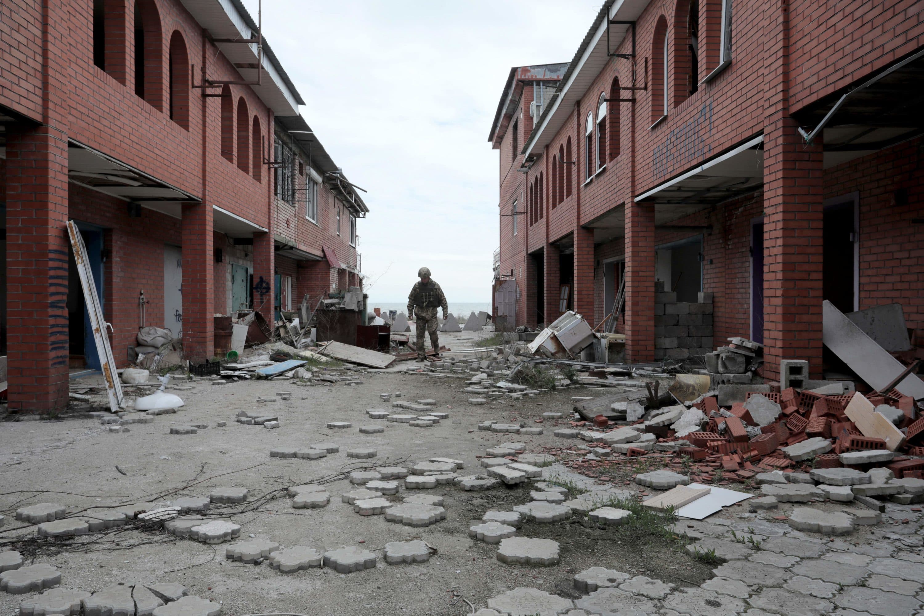 An Ukrainian serviceman walks past destroyed buildings in the village of Shyrokyne near Mariupol, the last large city in eastern Ukraine controlled by Kiev on April 26, 2021. (Aleksey Filippov/AFP via Getty Images)
